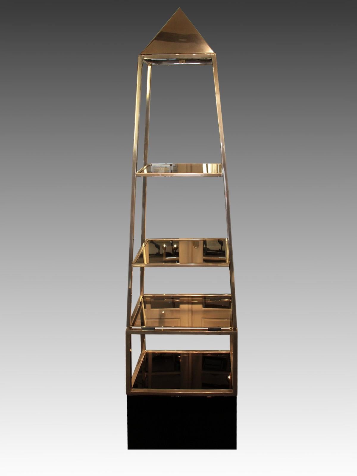 Rare pair of pyramid-shaped shelves, made by Maison Jansen, circa 1970.
Visible on all four sides and can be placed in the middle of a room, they are made of square nickel-plated brass tube on a base opening with two doors in black lacquered wood.