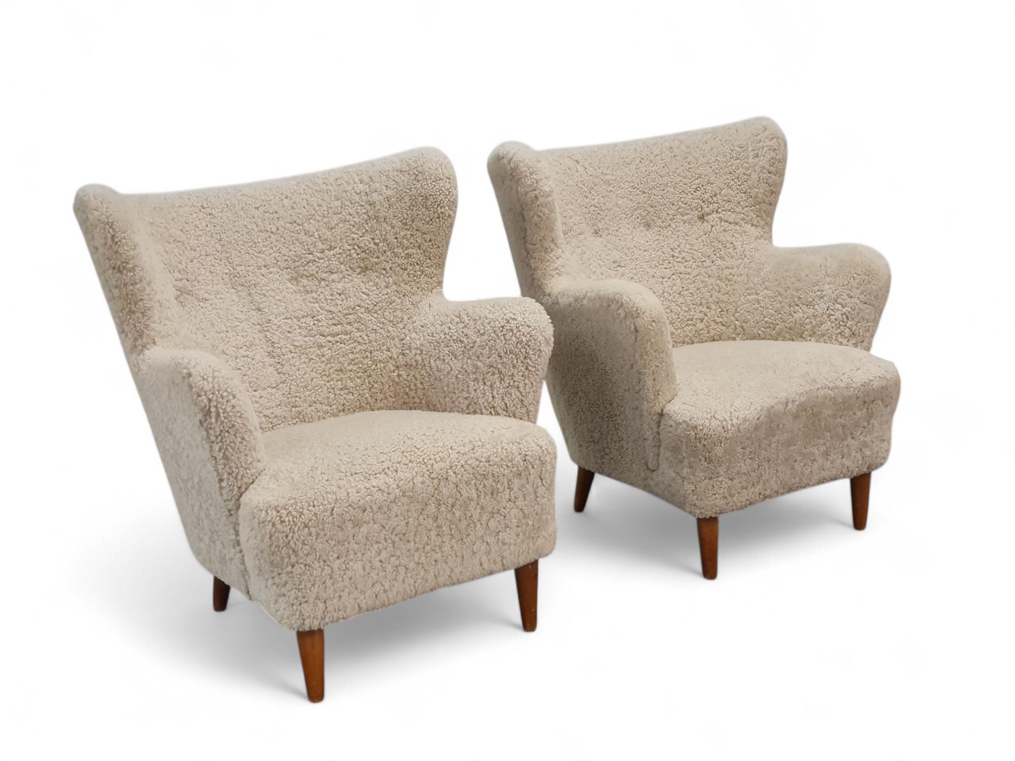 A pair of elegant armchairs designed by Ilmari Lappalainen and manufactured by Asko Oy in Finland in the 1940s. The chairs are reupholstered with natural sheepskin. Apart from the reupholstery the chair bodies are in original and very good