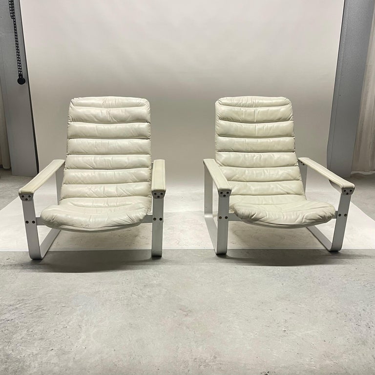 Rare pair of adjustable lounge club or arm chairs, rendered in dove gray leather with brushed cold rolled aluminum frame. These chairs are modeled after classic champaign furniture. The seat is adjustable in 3 positions to go from a seated high back