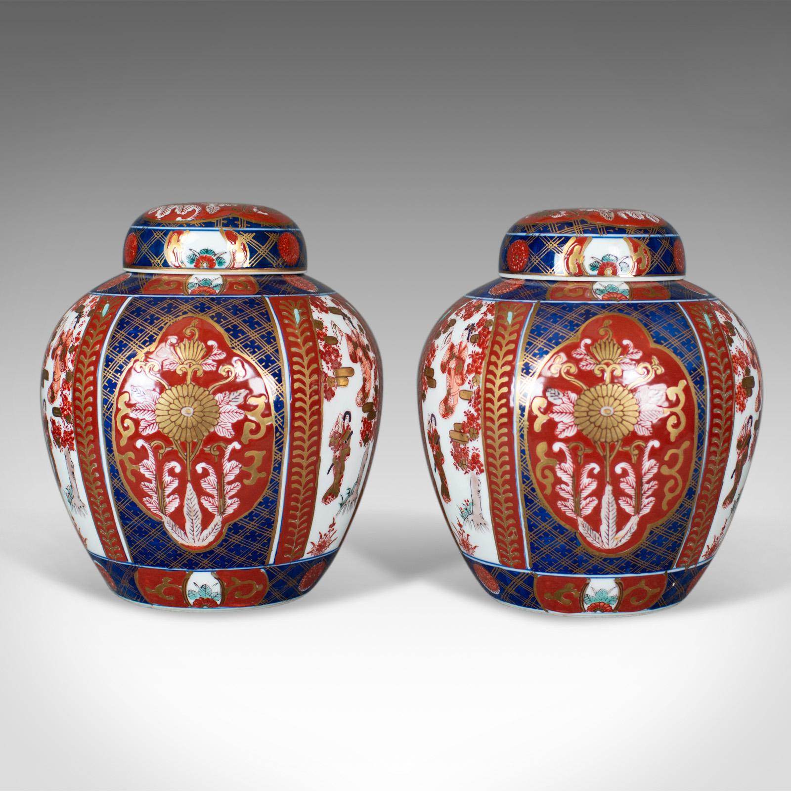 This is a pair of Imari ginger jars, profusely decorated porcelain spice jars with lids, dating to the mid-late 20th century.

Of classic form and in good proportion
Of quality craftsmanship, free from damage
Classic panelled design with mark to
