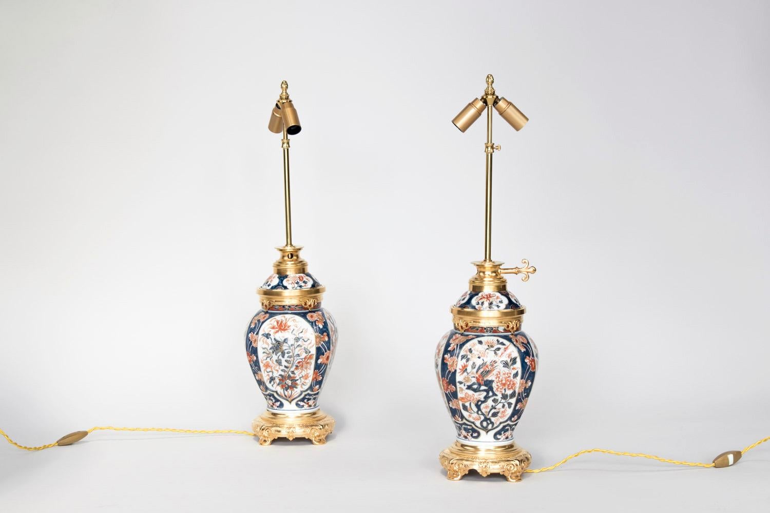Pair of canted corners vase shaped lamps in Imari Porcelain. Chiselled and gilt bronze mount, standing on a circular quadripod base with motifs of scrolls.
Blue background body lamp decorated with red flowers framing four large white background