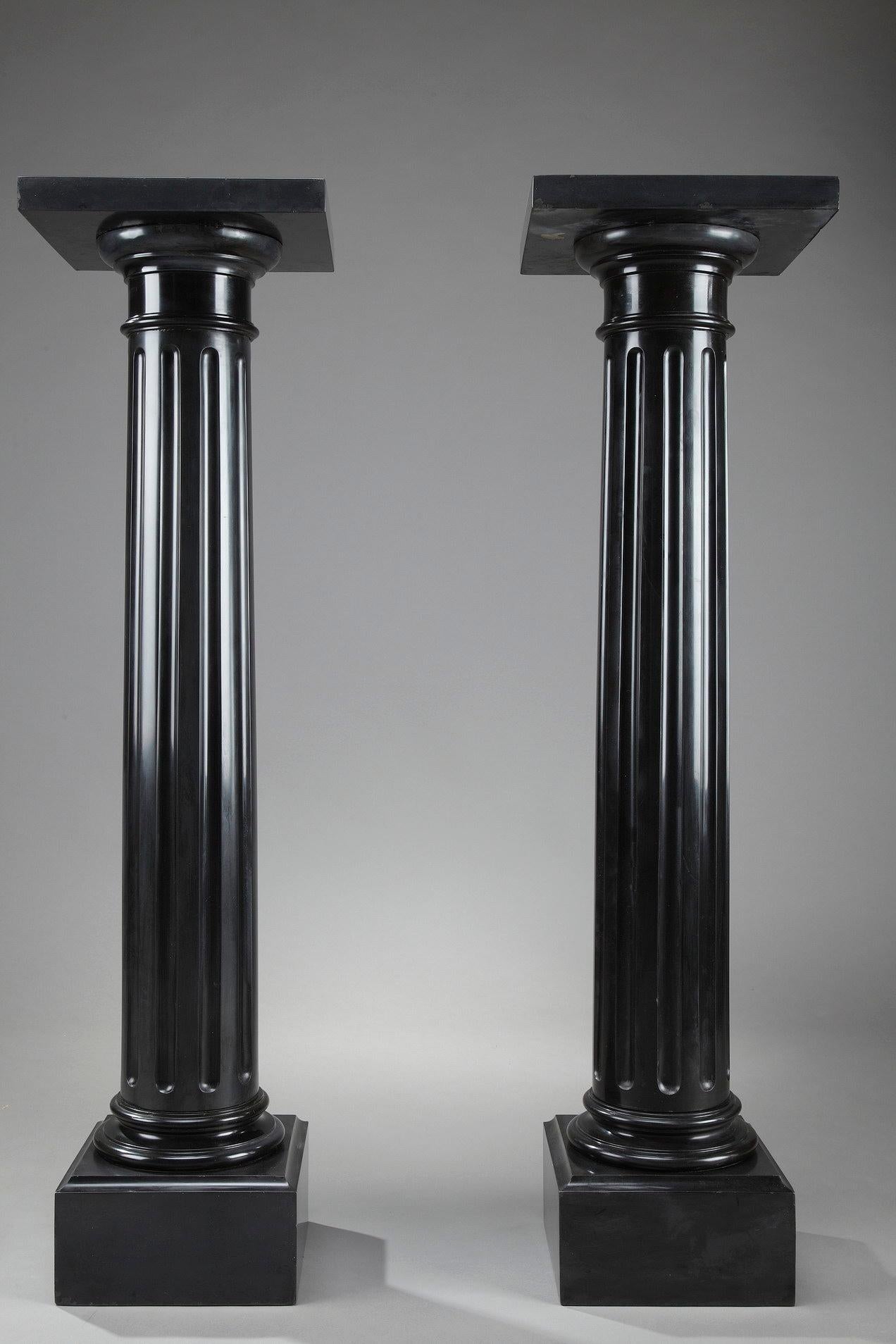 This pair of imperial black marble pedestals is crafted in the second half of the 19th century. Formed as Doric columns, these neoclassical pedestals are decorated with flutes. The capital supports the plate designed to display a light fixture or an