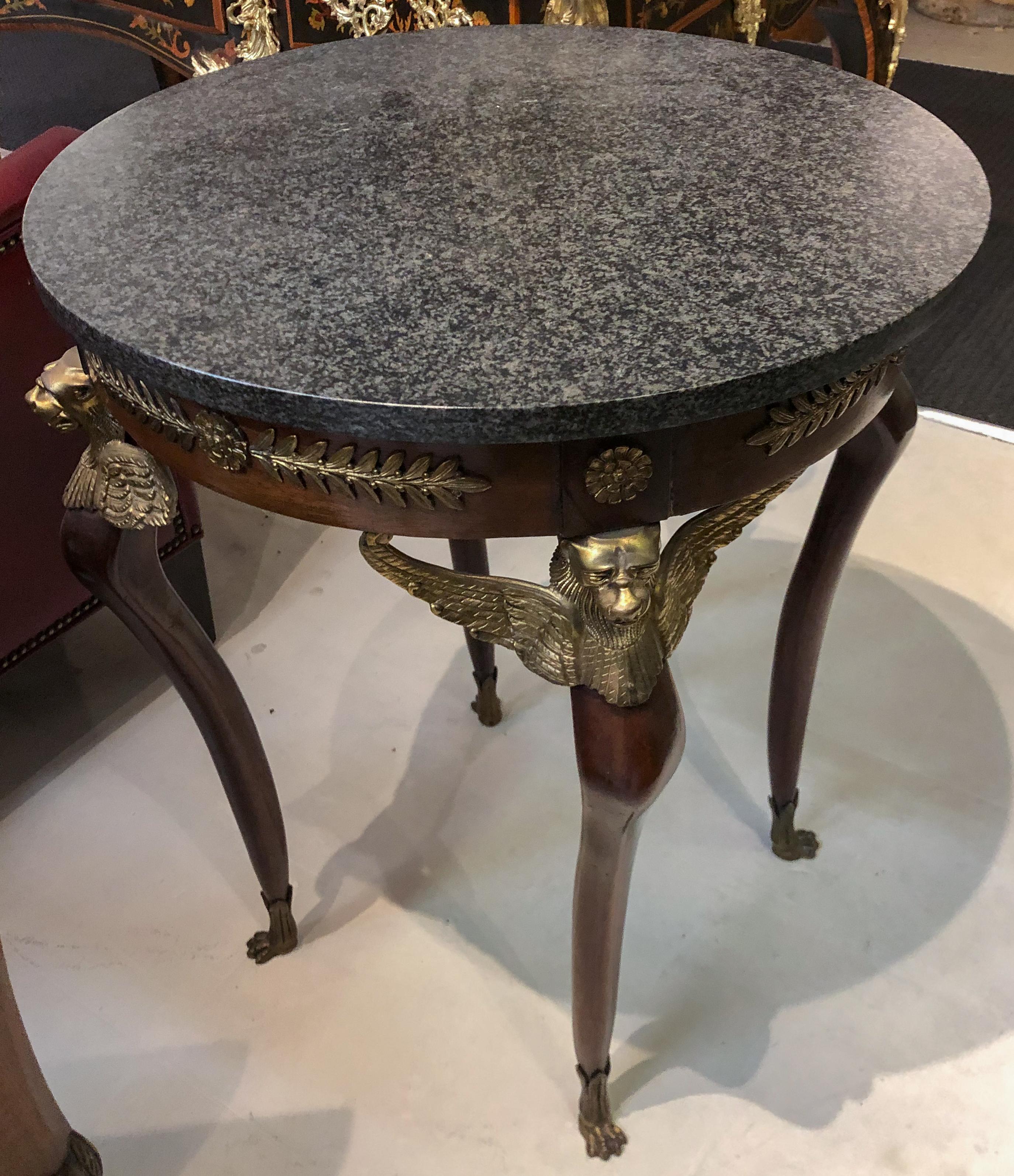 Pair of Imperial Empire style side or center tables with marble top and gilt griffin details.