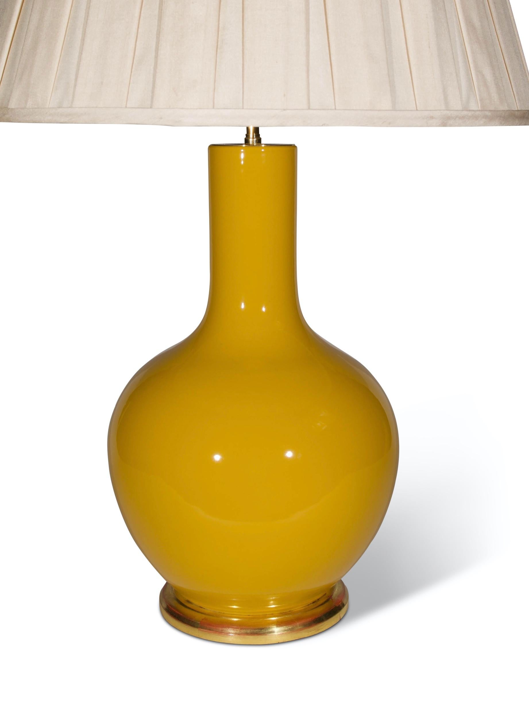 A fine Chinese porcelain Imperial Yellow glazed straight necked vase, now mounted as a lamp with a hand gilded turned base.

Height of vase: 16 1/2 in (42 cm) including giltwood bases, excluding electrical fitments and lampshade.

All of our lamps