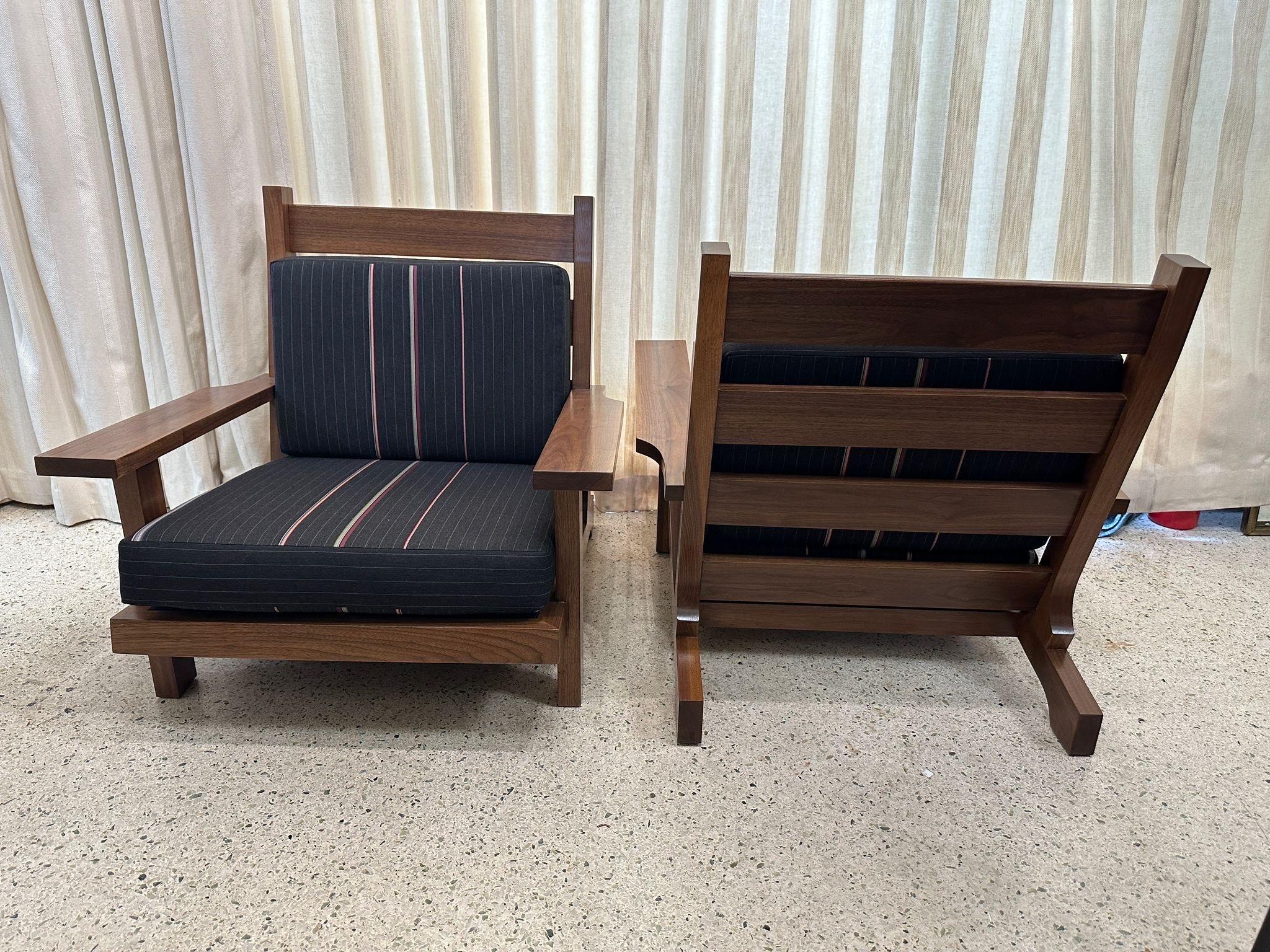 Queste meravigliose poltrone basse in noce con cuscini in tessuto di lana morbida di Paul Smith. Queste sono larghe, profonde e basse per un'ottima seduta.  Sono stati acquistati dalla proprietà di Amy Perlin, New York.
