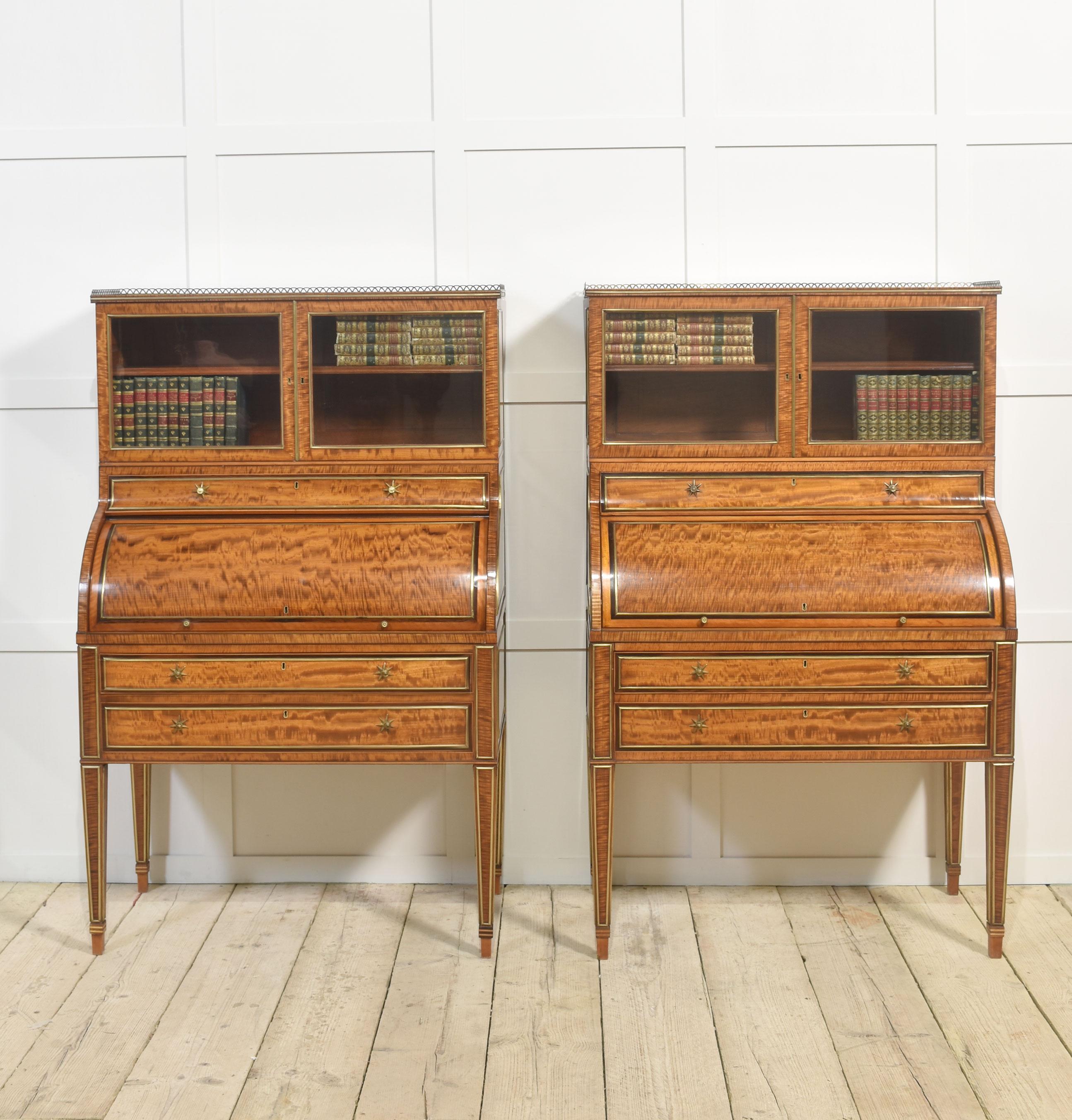 Pareja de armarios/libreros cilíndricos georgianos, con galería calada en relieve y tapas de madera de satén bien labradas, puertas acristaladas que se abren para dejar ver una balda ajustable. El congelador tiene frentes cilíndricos que se abren