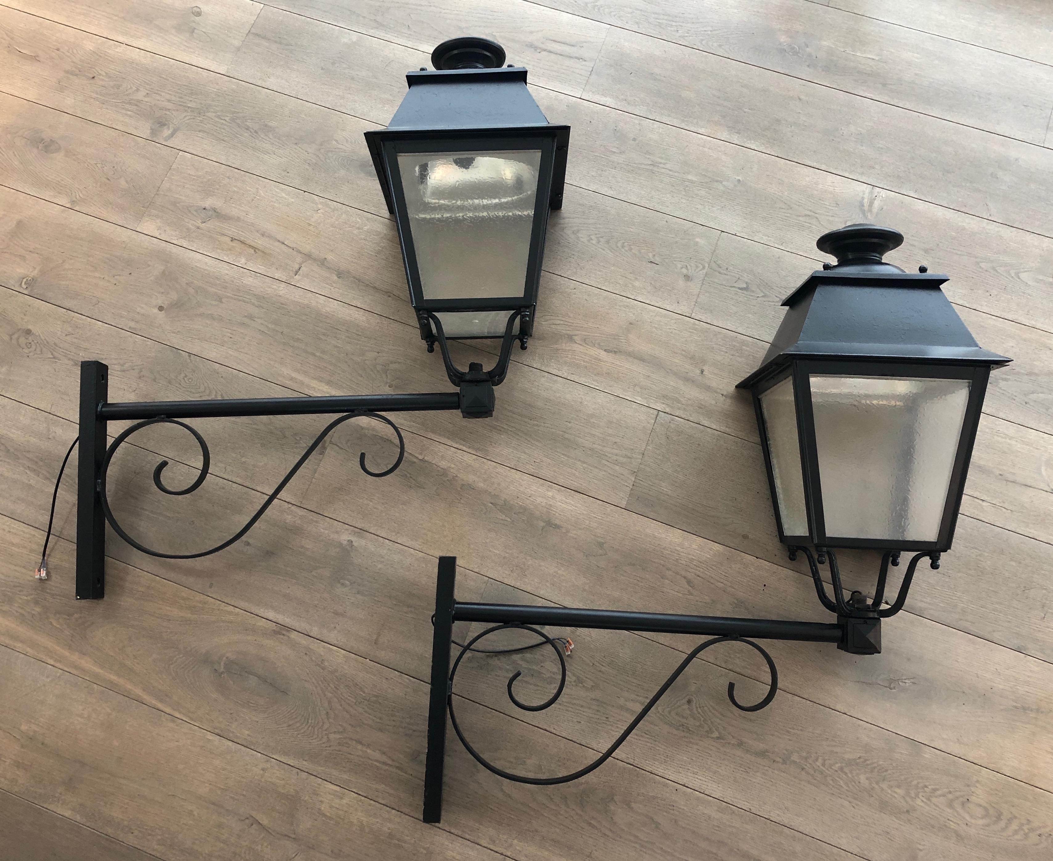 This very nice and decorative pair of important outside lanterns on brackets is made of iron and sheet metal. This is a French work. Circa 1950