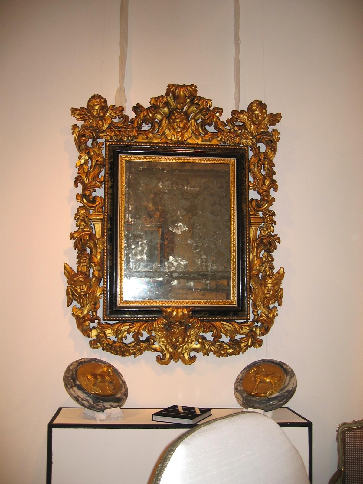 Eccezionale coppia di specchiere in legno dorato intagliato e rifinito con una preziosa lastra rettangolare in tartaruga con cimieri a foglie d'acanto, elementi architettonici, putti alati e teste di fiori a volute, centrate dai suoi specchi