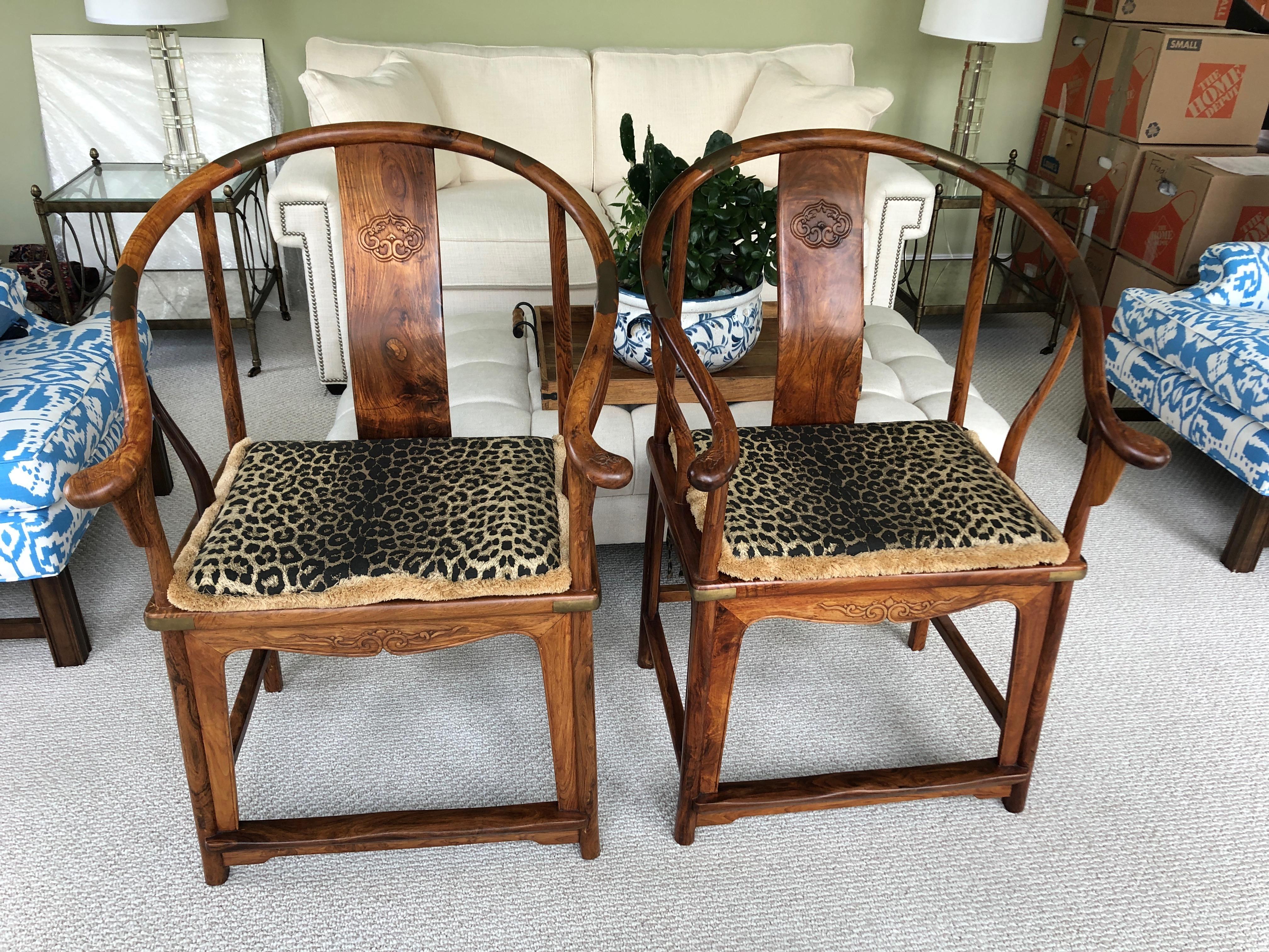 Marvellous pair of Chinese Qing dynasty horseshoe armchairs having gorgeous grained Huanghuali wood, curvy back rail and arms that form a continuous semi circle. Coupled with tapered S-curved shaped side posts, on the back splats there is a relief