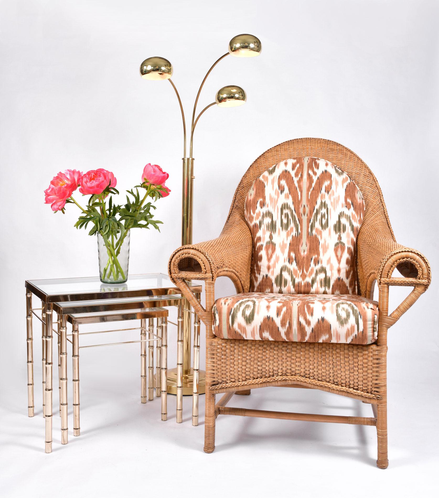 Imposing pair of wicker chairs featuring a range of decorative and detailed woven work. High backed and very comfortable. A perfect addition to any conservatory.

Smooth arms end in a semi circular detail. Upholstered in Ikat style cotton which