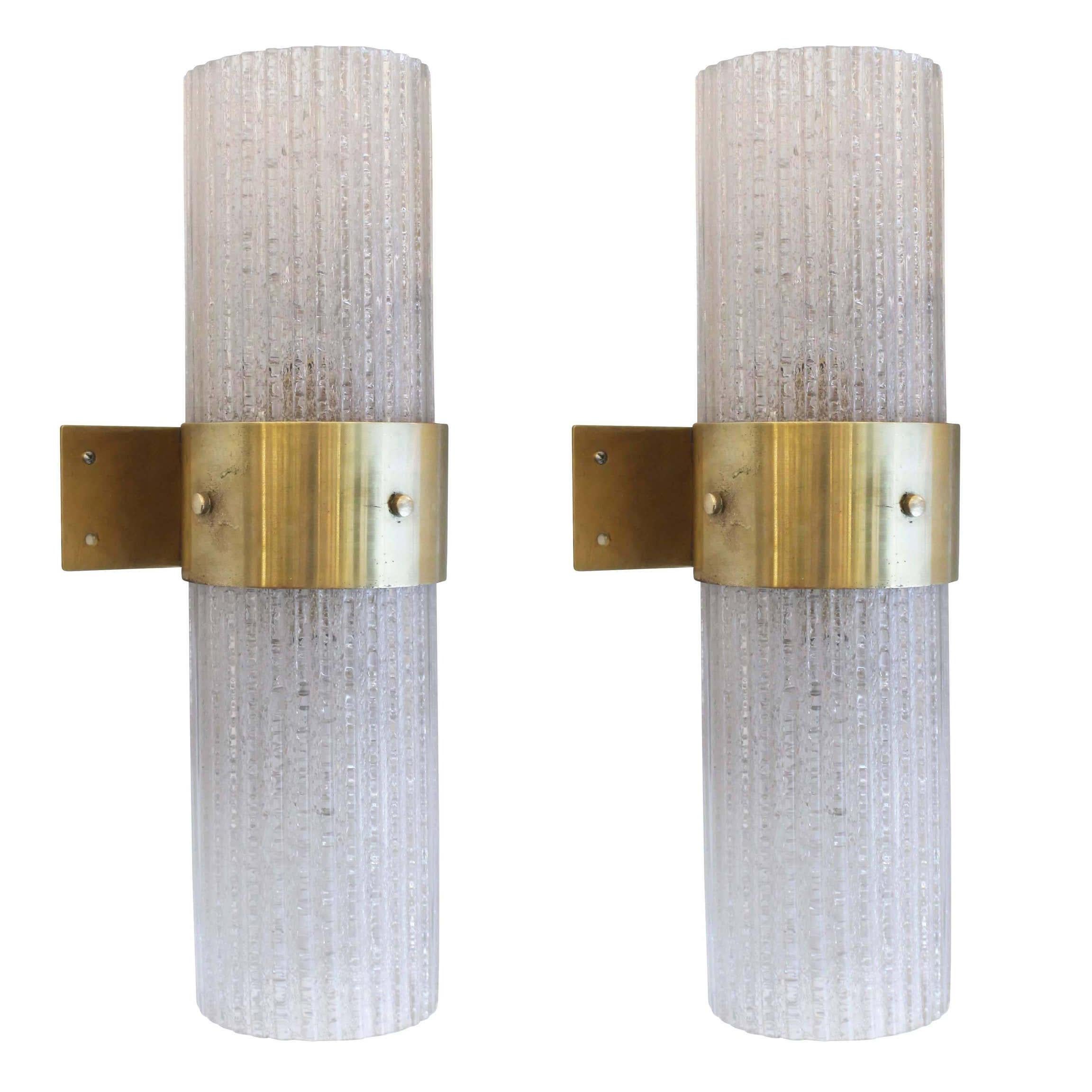 Pair of large glass sconces with brass brackets from a palace in, Florence. The glass is ribbed and textured so that the light bulbs are not visible. Each holds two regular sockets in order to light up any large space.