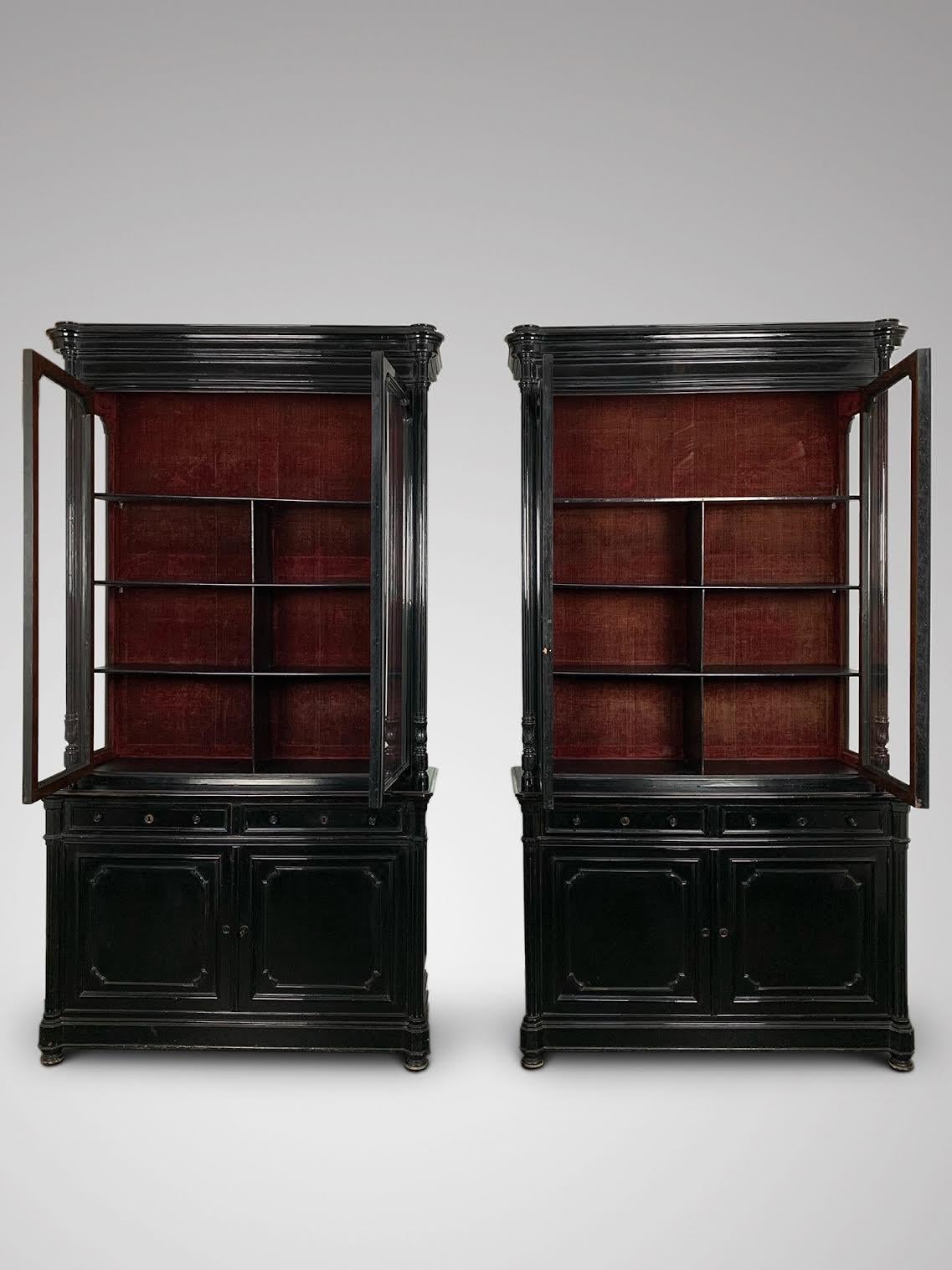 We are delighted to offer for sale this stunning pair of impressive 19th century French ebonized cabinets or bookcases. It features a rounded moulded cornice above a pair of shaped glazed doors, side panelled glass, flanked by a pair of carved,
