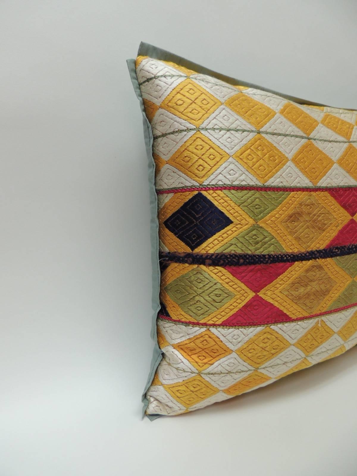 Pair of Indian 19th century “Phulkari” Artisanal decorative bolster pillow
The front pattern is made of silk embroidered diamonds with a colorful band of larger diamonds in the center creating a striped design of larger diamonds across the front