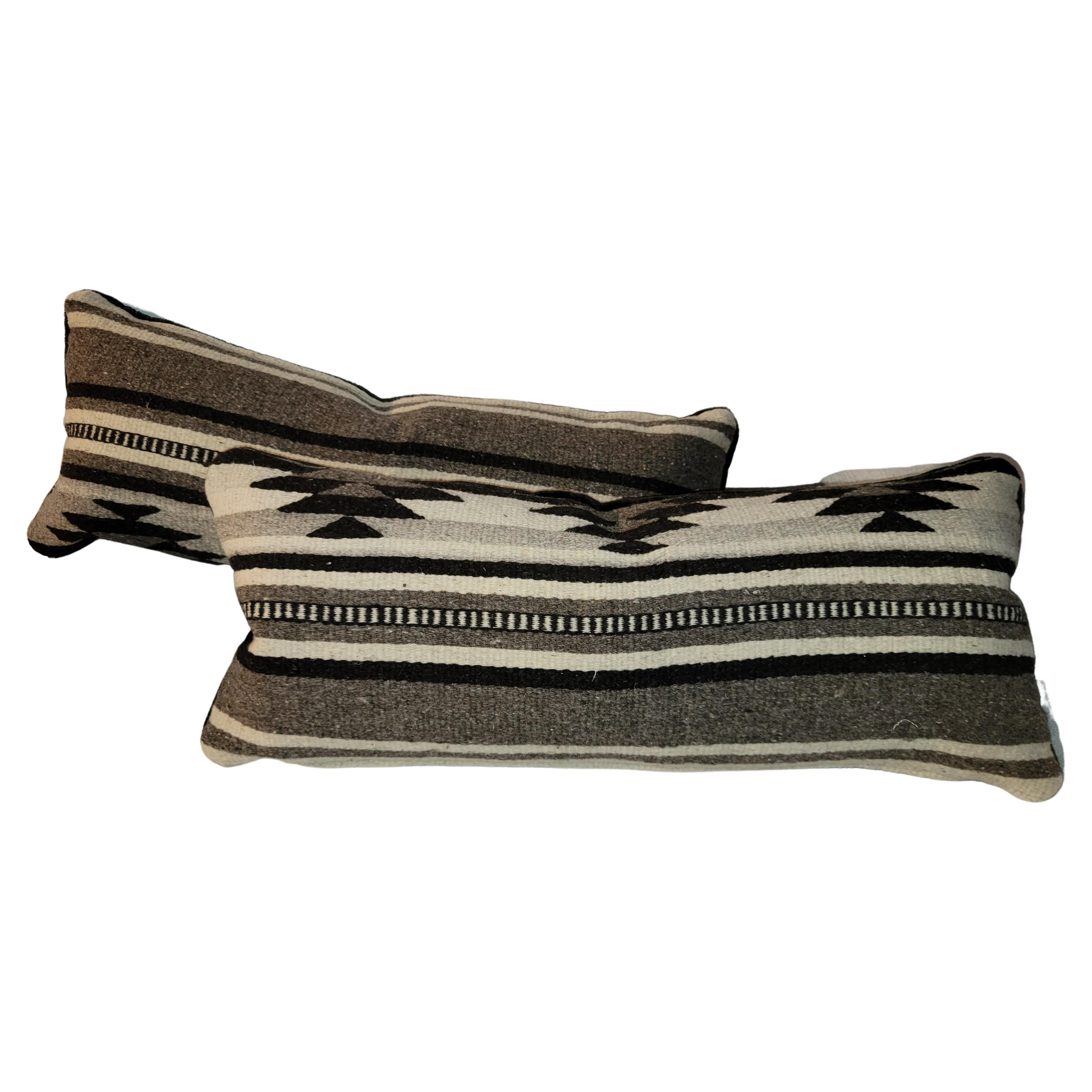 Pair of Indian Weaving Bolster Pillows. Black backing. Feather and down inserts. Zippered casing.