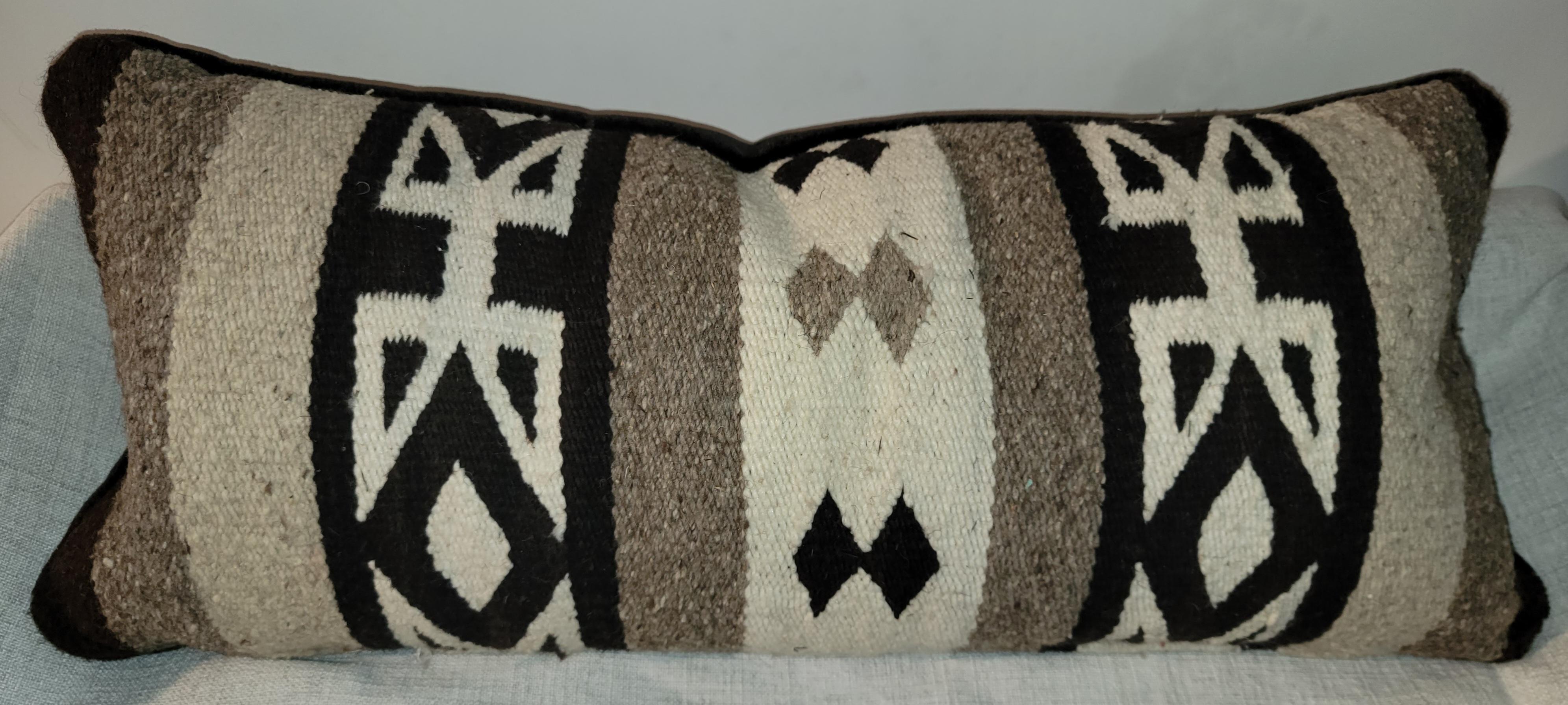Pair of Indian weaving bolster pillows. Blacking backing. Feather and down inserts and zippered casing.