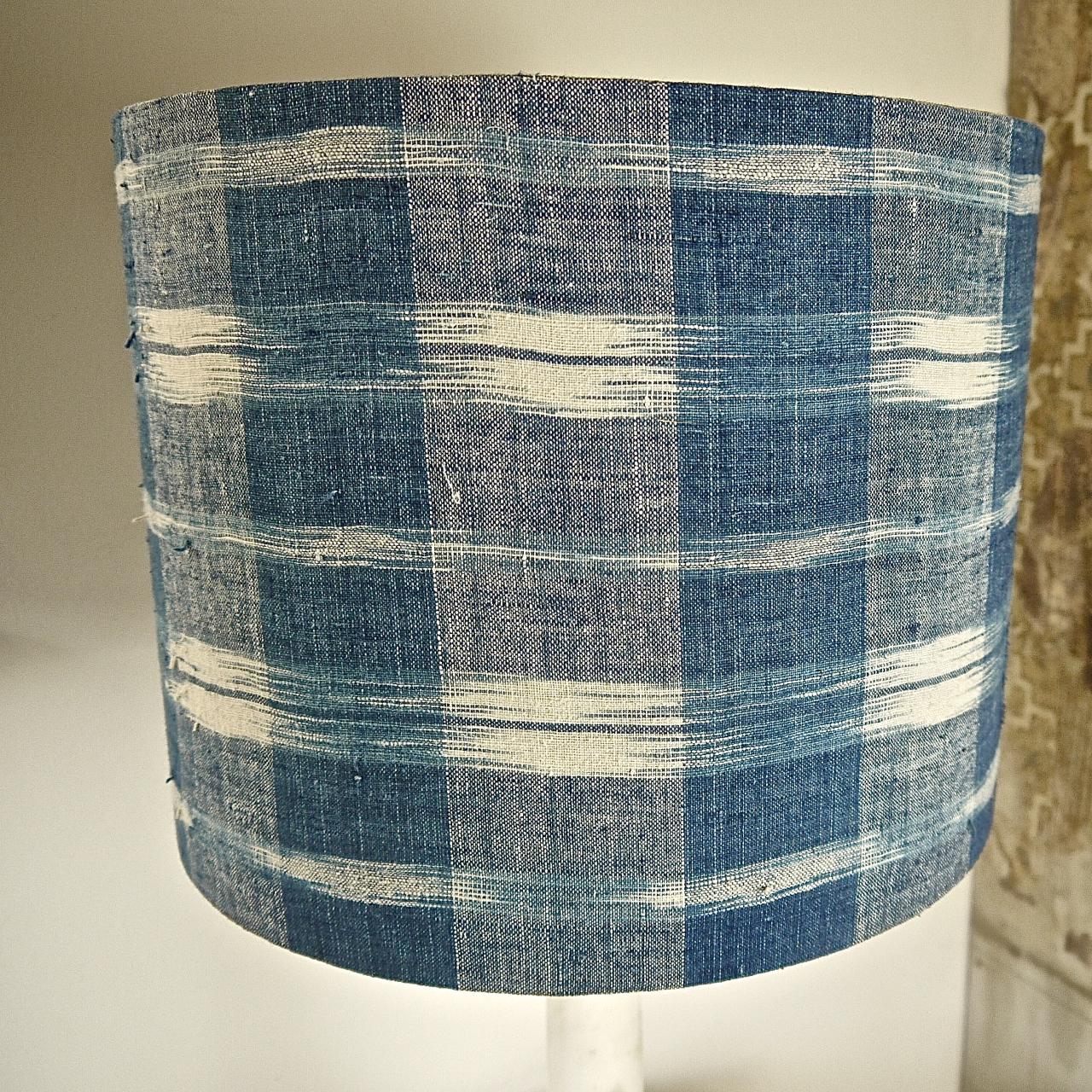 Pair of French late 18th century beautifully and softly faded indigo ikat/flamme coarsely woven cotton covering a drum lampshade.
The inside is covered in an off white cotton.