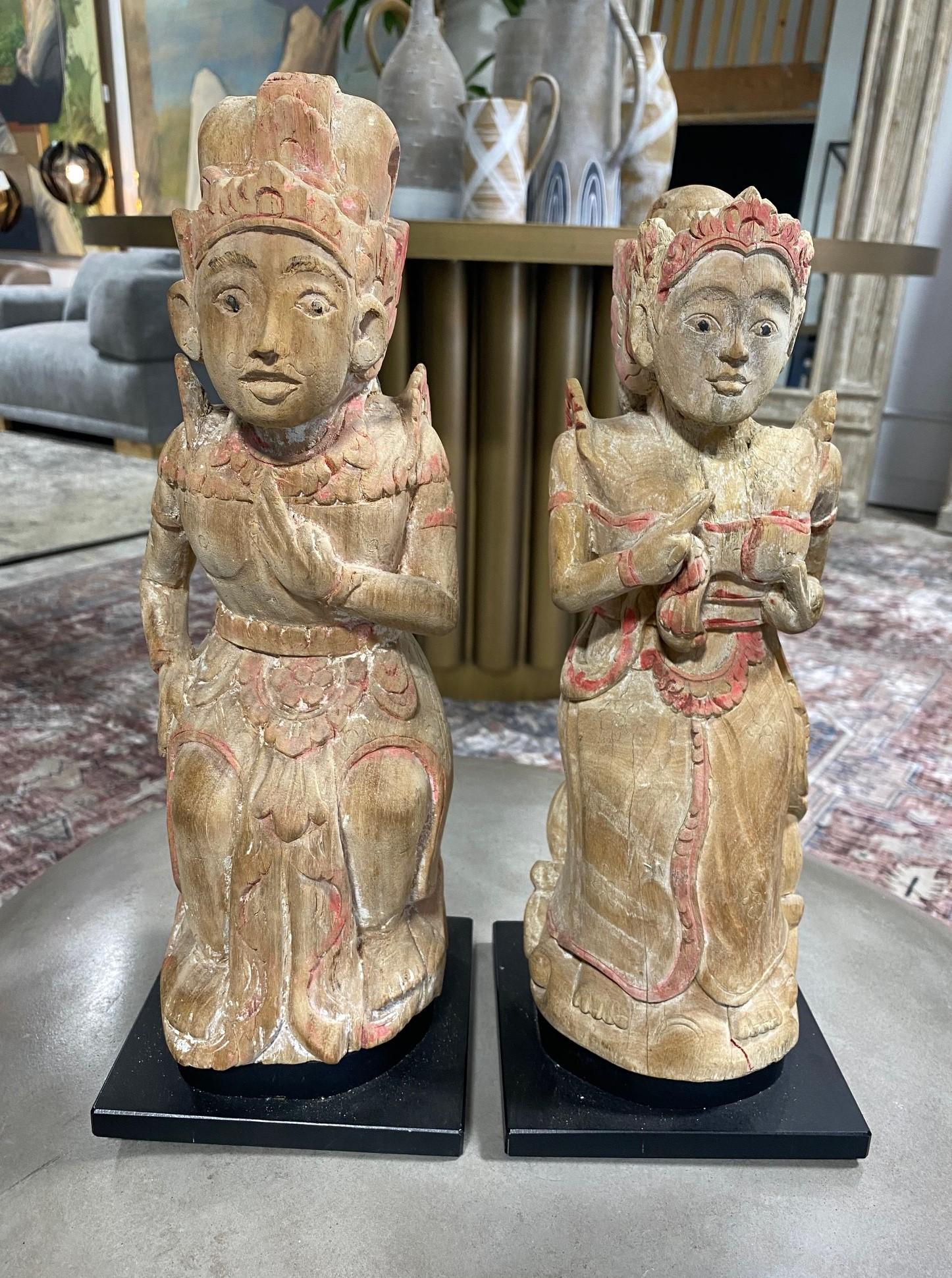 Wonderful, unique hand carved wood and polychrome pair of Indonesian Balinese devotional figures/ statues from the island of Bali. 

This pair, likely from the early to mid 20th century, has a nice aged patina with remanents of the original paint