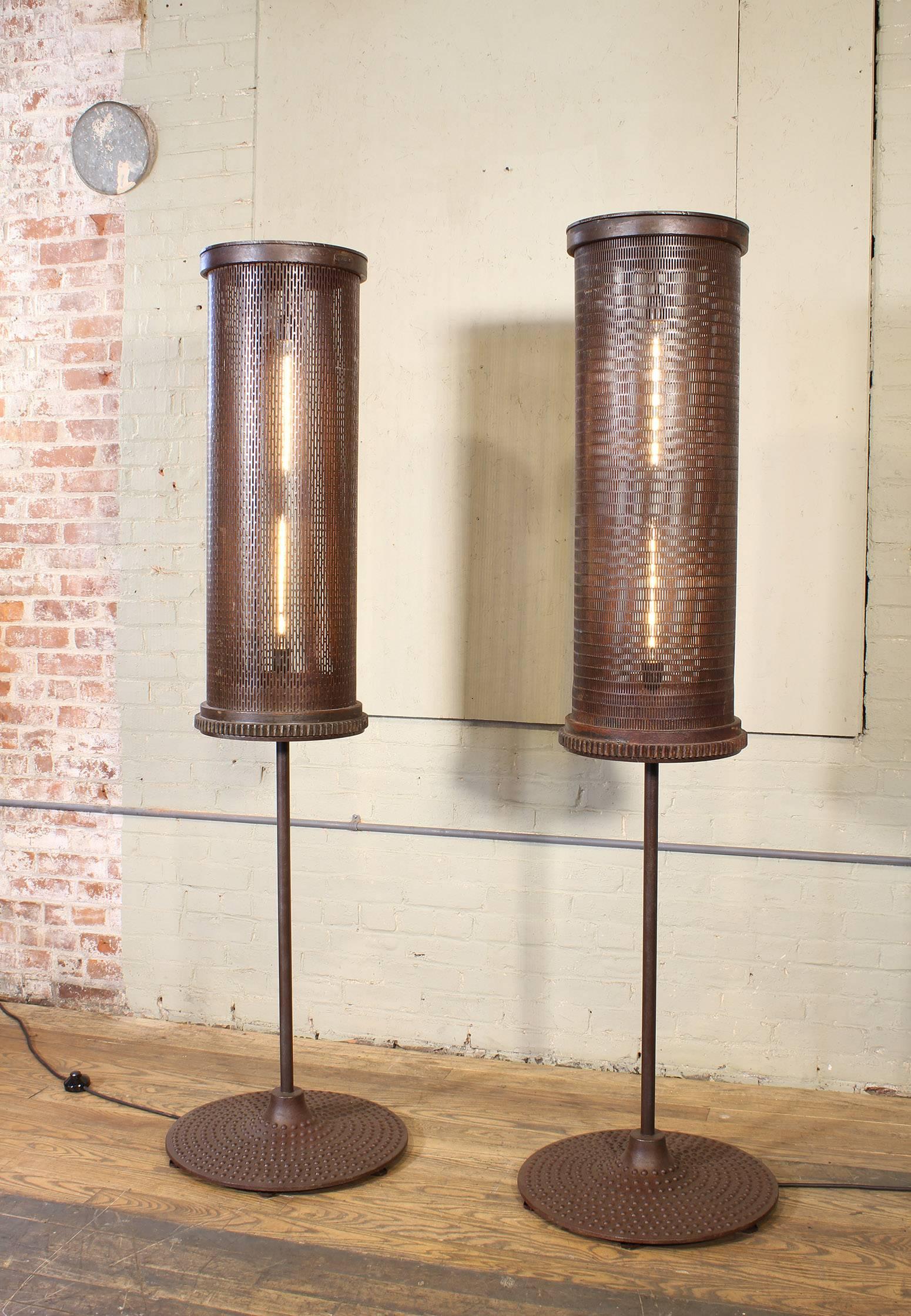 Pair of Industrial / Brutalist style 6' floor lamps. Turn of the century factory tumblers atop vintage steel machine bases. Features a foot switch and 40w Edison style tube bulbs. 72
