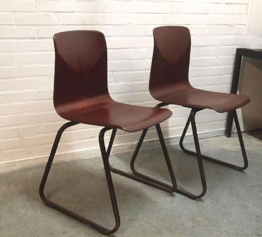 A pair of industrial Pagholz Galvanitas stacking chairs model S23 Thur-Up Seat by Elmar Flötotto, circa 1970. This beautiful design from the 1970s with solid black lacquered steel frames and brown grain structure wooden seats provide optimal