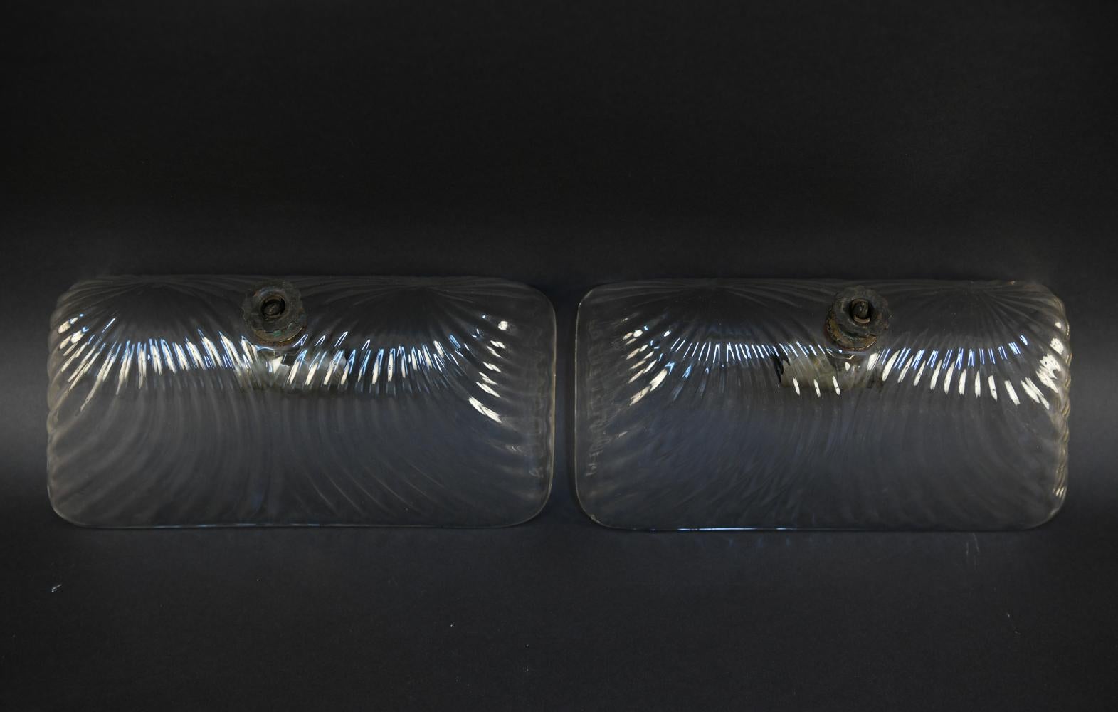 These industrial glass shade sconces are circa 1910. Featuring ribbed glass in a domed rectangle form.