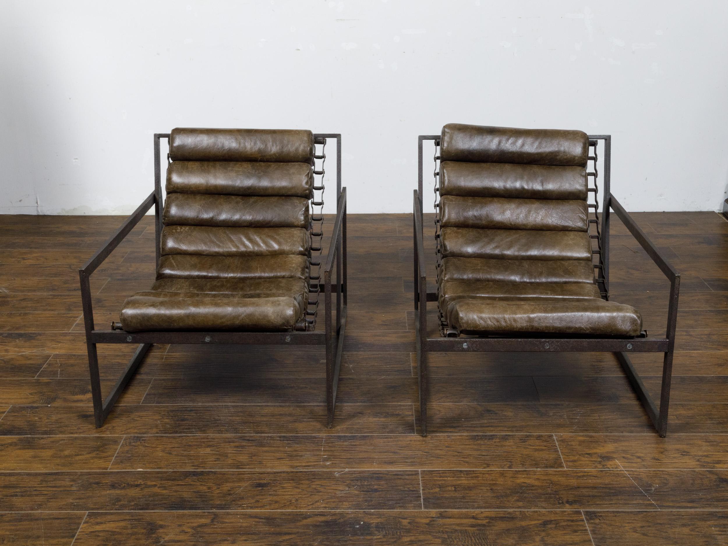 A pair of Industrial iron and leather sling transat chairs from the 20th century. This pair of 20th-century Industrial iron and leather sling 