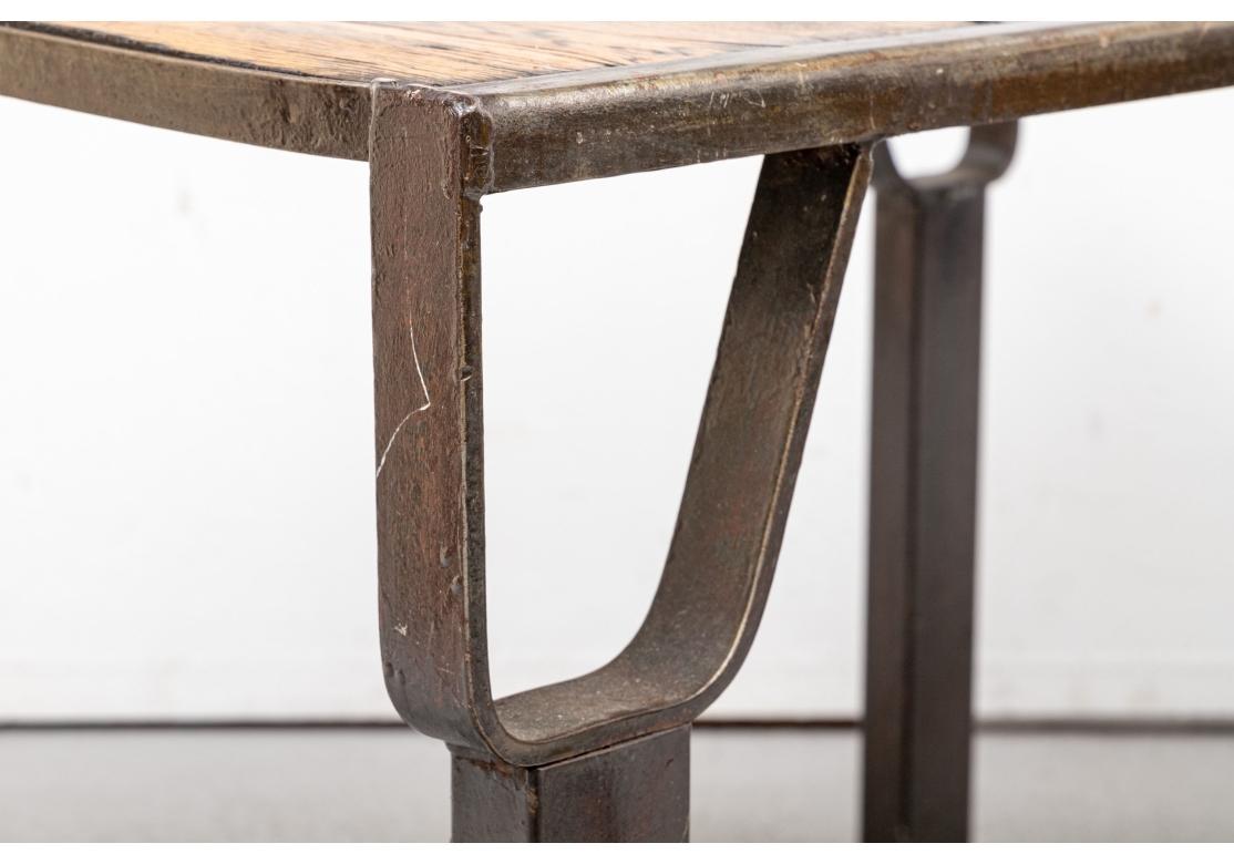 Ein sehr solides Paar Tische im Industriestil mit großem Gewicht und solider Haptik. Holzplatten in Plankenbauweise, verwittert und gebeizt, aber mit feiner Satinierung. Mit geschwärzter Eisenumrandung und auf Eisenbeinen mit durchbrochenen