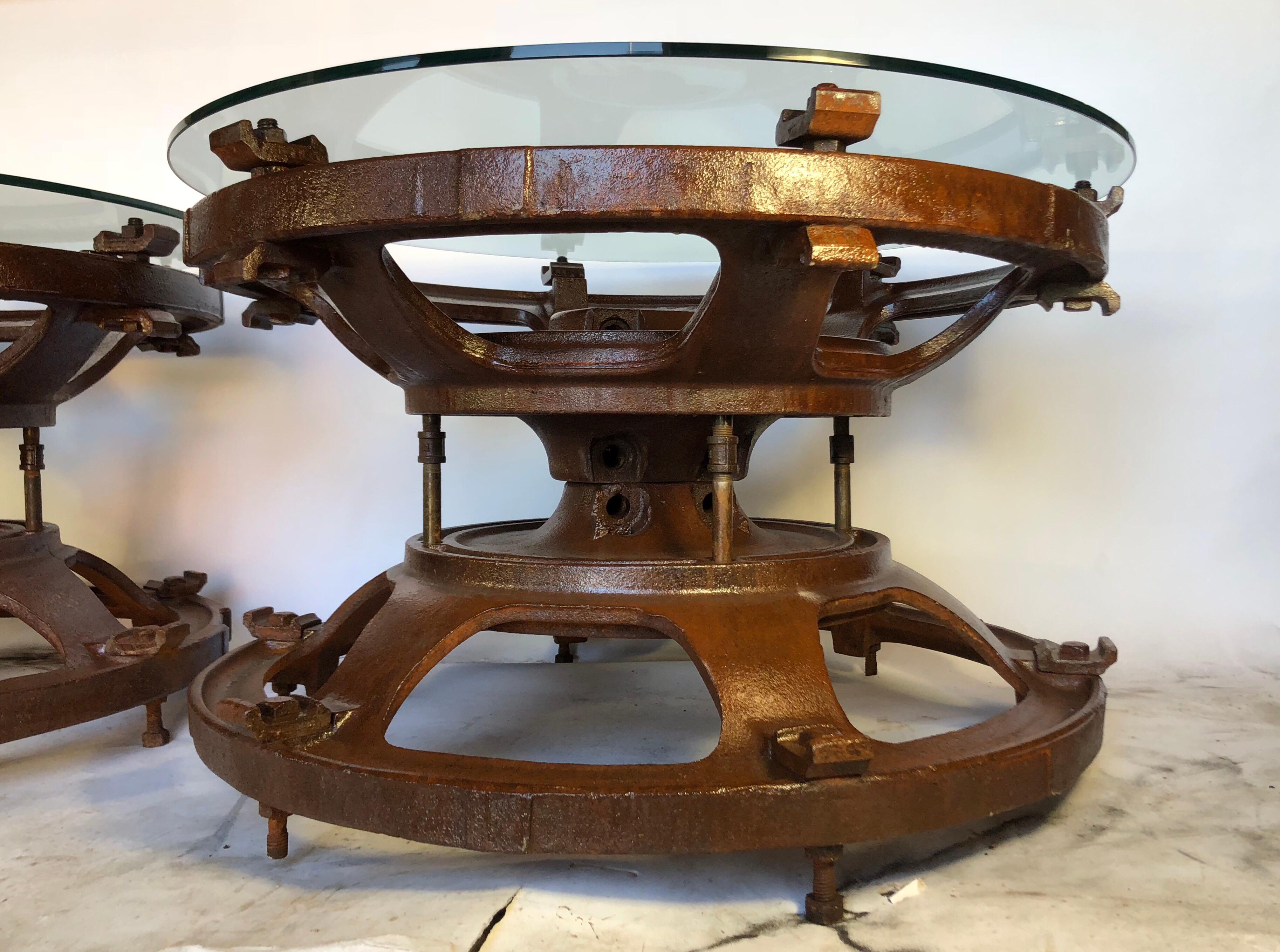 Pair of rusted steel tractor wheel side tables. Cast steel with clear coat over rust and glass tops. Very sturdy and heavy. Free delivery within the New York area.