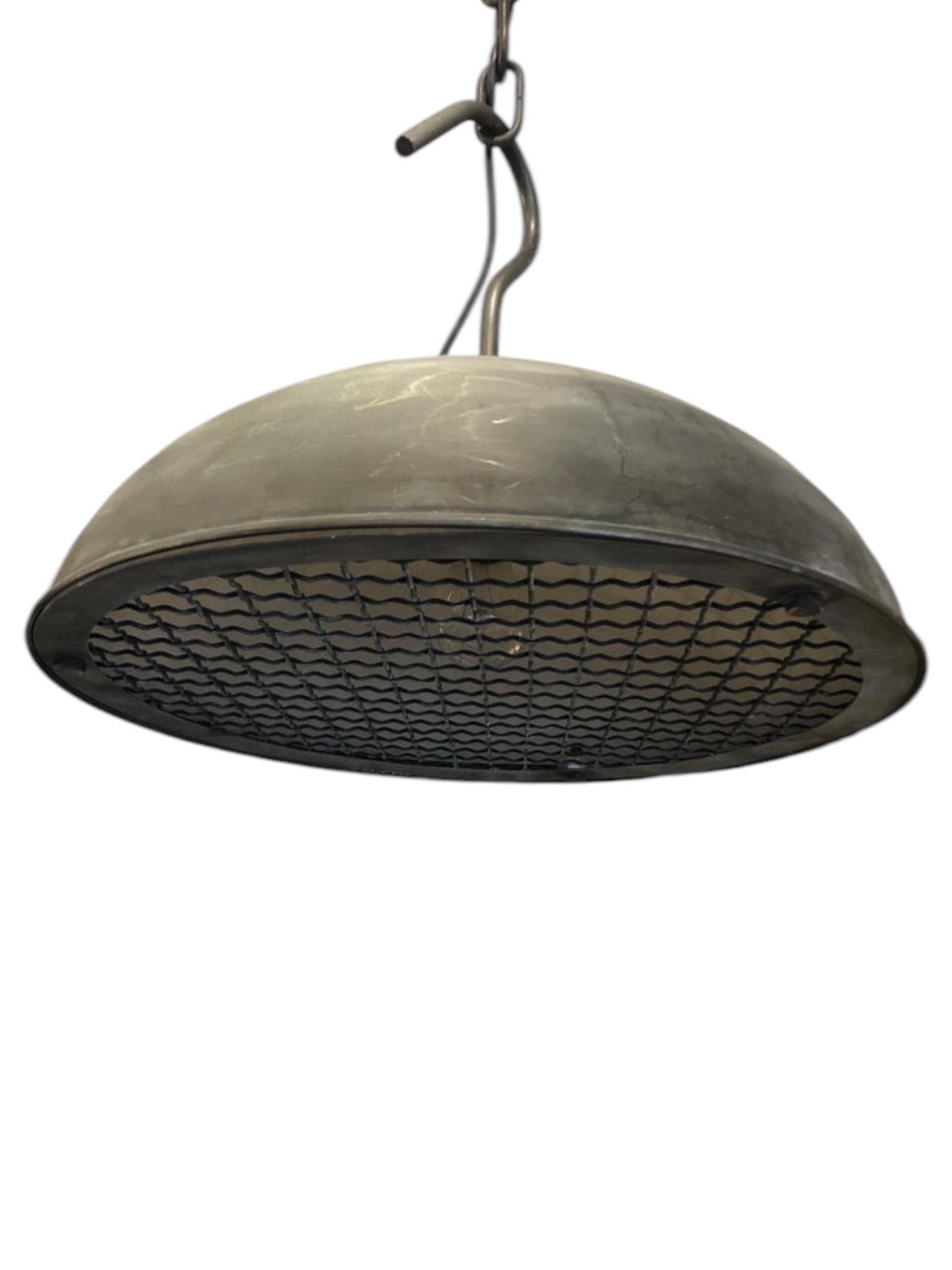 Bold and functional, this pair of industrial warehouse-style pendant lights brings a raw, utilitarian charm to any space. Featuring dome-shaped metal shades with a distressed gunmetal finish and perforated diffusers underneath, they offer both style