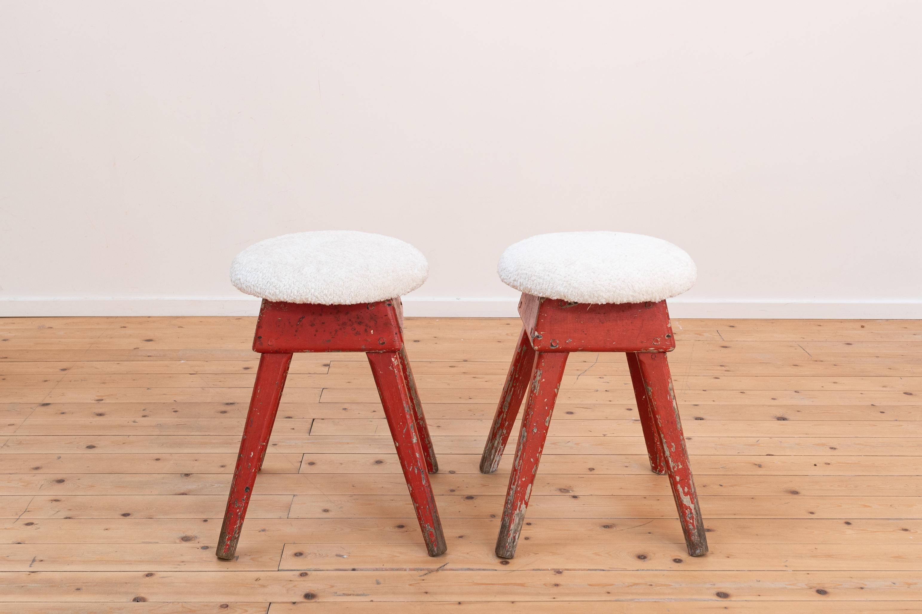 Pair of industrial wooden stool with new wool off-white upholstery. 

The stools were in a workshop and were left in their original state, apart from the new upholstery. The red paint is also authentic. 