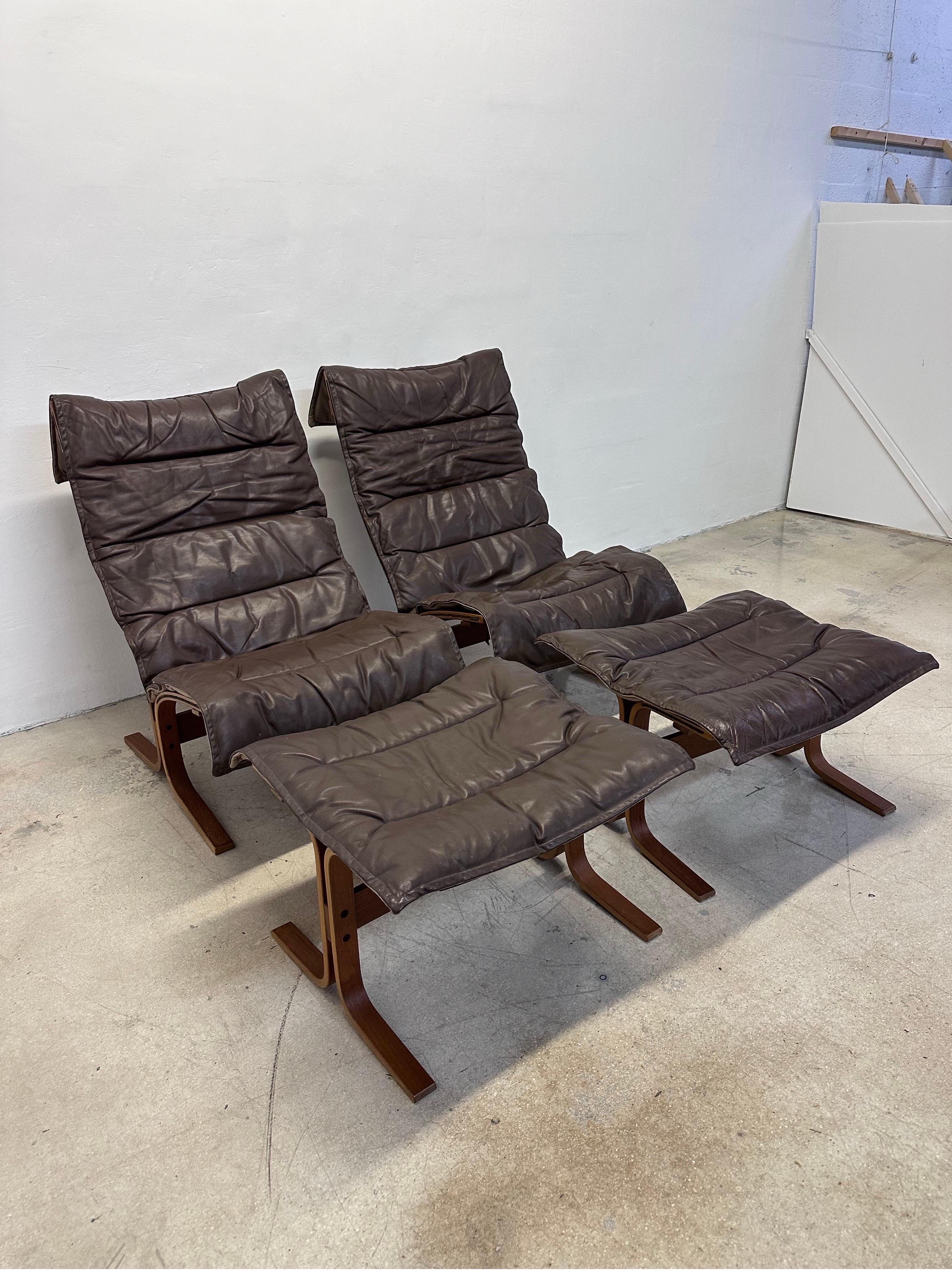 Rare paire de chaises Siesta à haut dossier en cuir brun et bois d'Ingmar Relling avec repose-pieds pour Westnofa. 1960s.

Mesures séparées :
Chaise L26