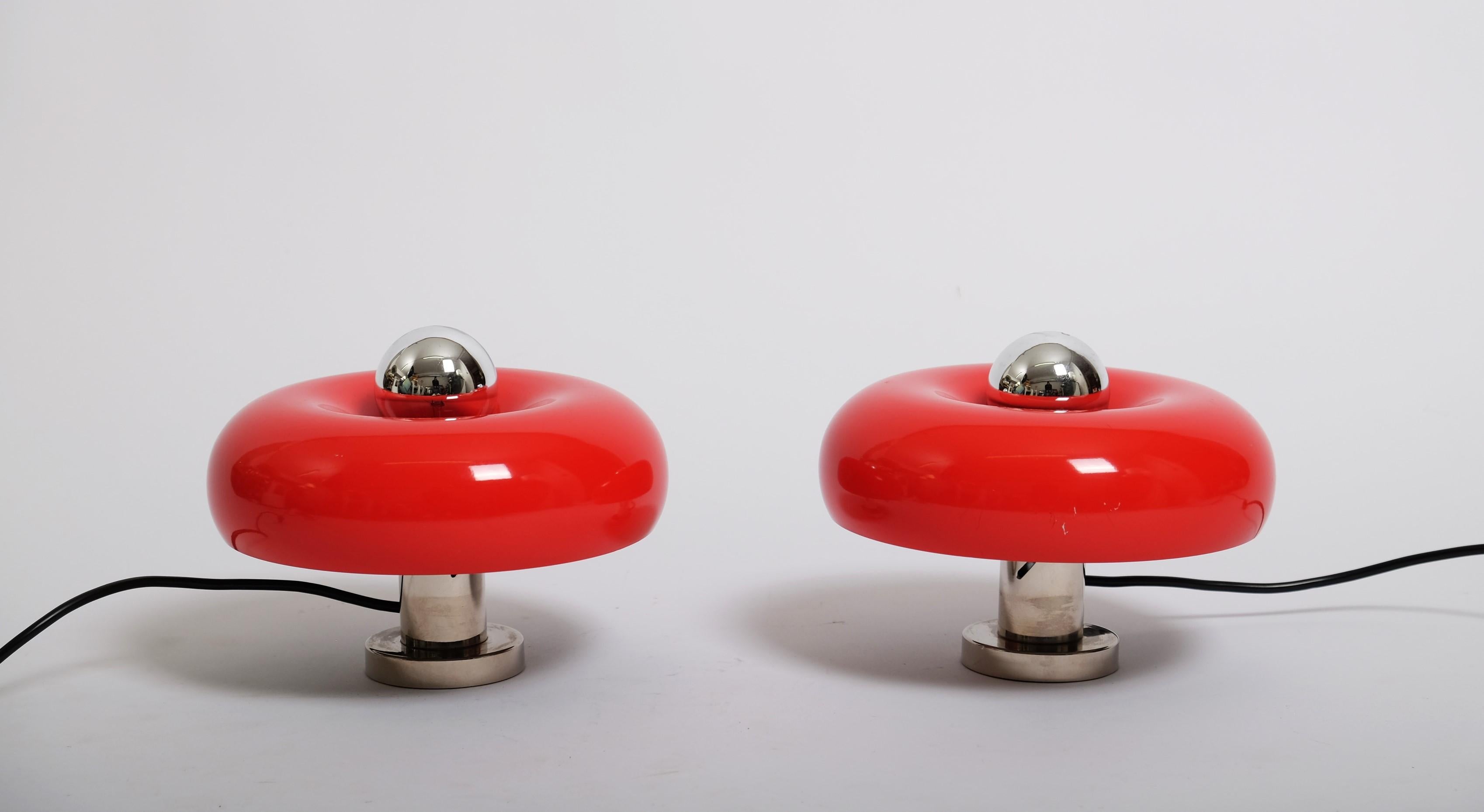 Very nice pair of sconces or table lamps designed by Ingo Maurer, Germany 1960s. These lamps have a bit of a donut shape and the red lacquered shade can be adjusted in height. The lamps are easy to wall hang but can also be used as a table lamp.