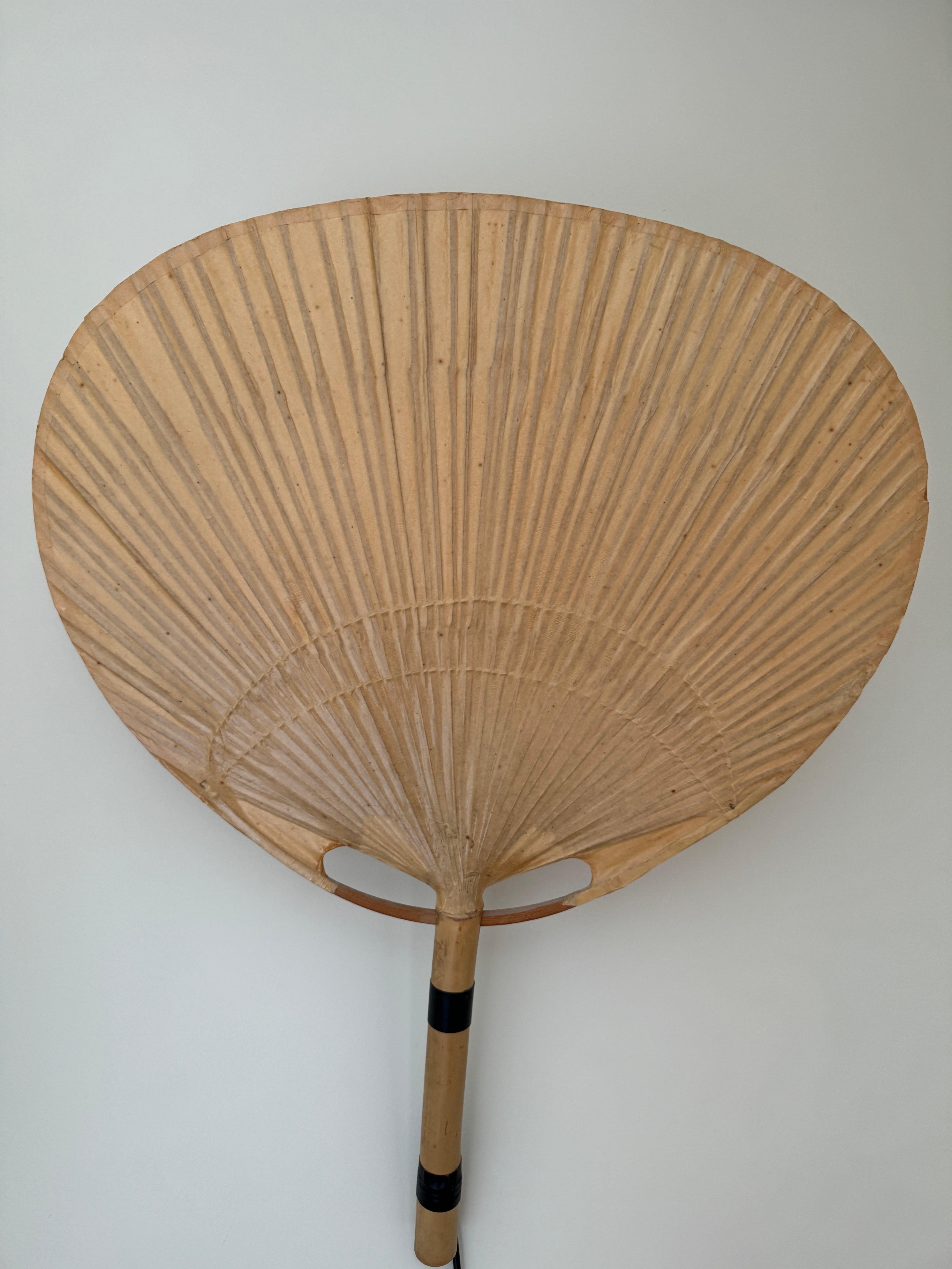 An extremely rare pair of Uchiwa III wall lamps designed by Ingo Maurer in the 1970s and manufactured by M-Design Munich. The Uchiwa III is a medium version of the wall lights within the Uchiwa series. These wall lamps are comprised of bamboo and