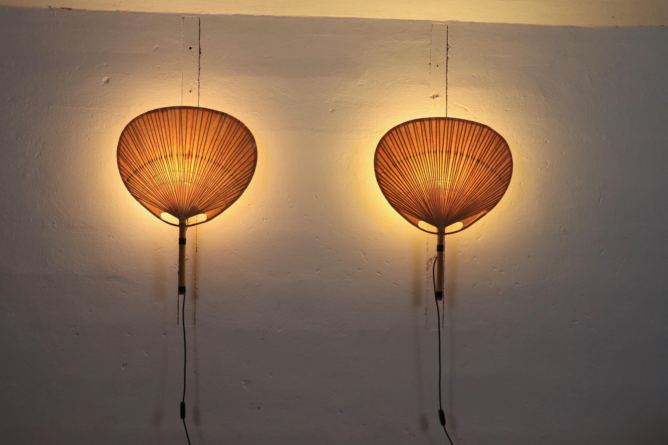 Incroyable paire d'appliques murales Uchiwa III conçues par Ingo Maurer pour M-Design, Allemagne 1973.

Les abat-jour, fabriqués en bambou et en papier de riz, diffusent une lumière chaude étonnante. Inspirées des éventails traditionnels japonais