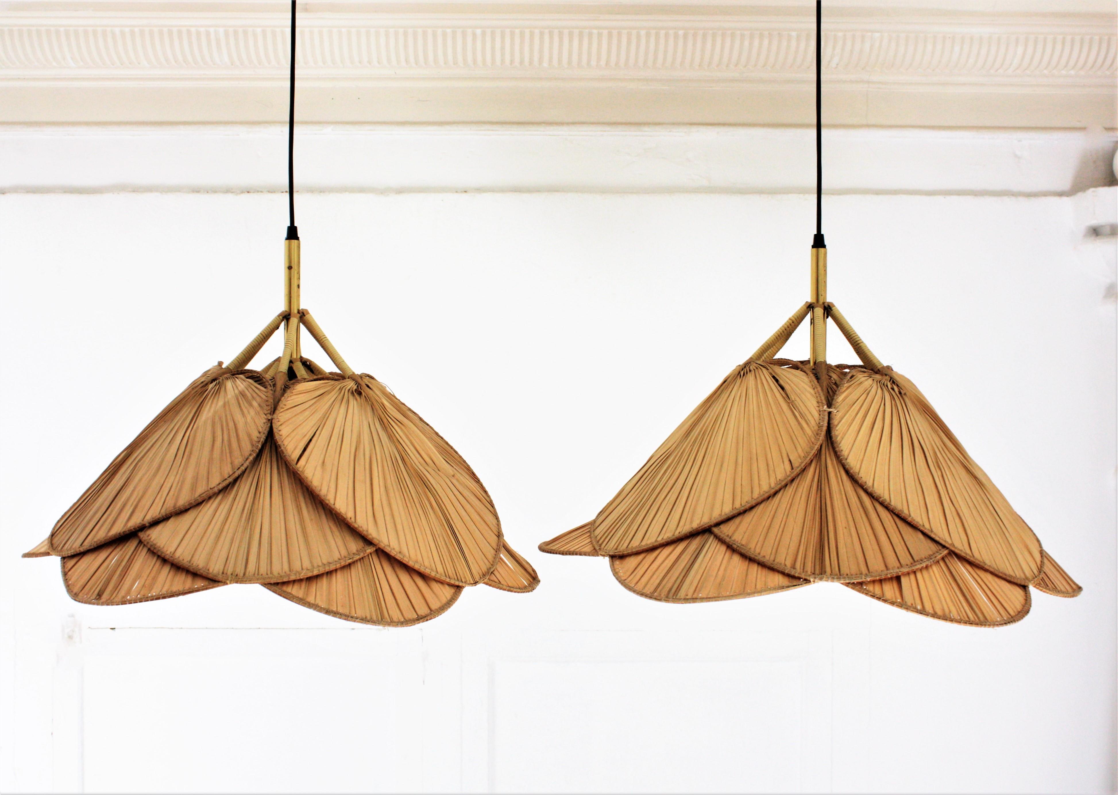 Pair of iconic palm leaf 'uchiwa' suspension lamps by Ingo Maurer, Germany, 1970s.
12 'Uchiwa' leaves fans each lamp.
These iconic pendants consist of twelve fans made of natural palm leaf. Uchiwa leaves fans are positioned as a flower around a