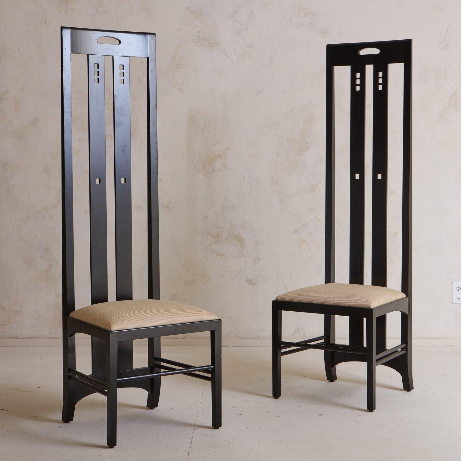 A pair of 1970s Ingram dining chairs attributed to Charles Mackintosh for Cassina. These chairs were constructed with ash wood and have a lacquered ebony finish. They feature dramatically high backs with geometric cutout details and an upholstered