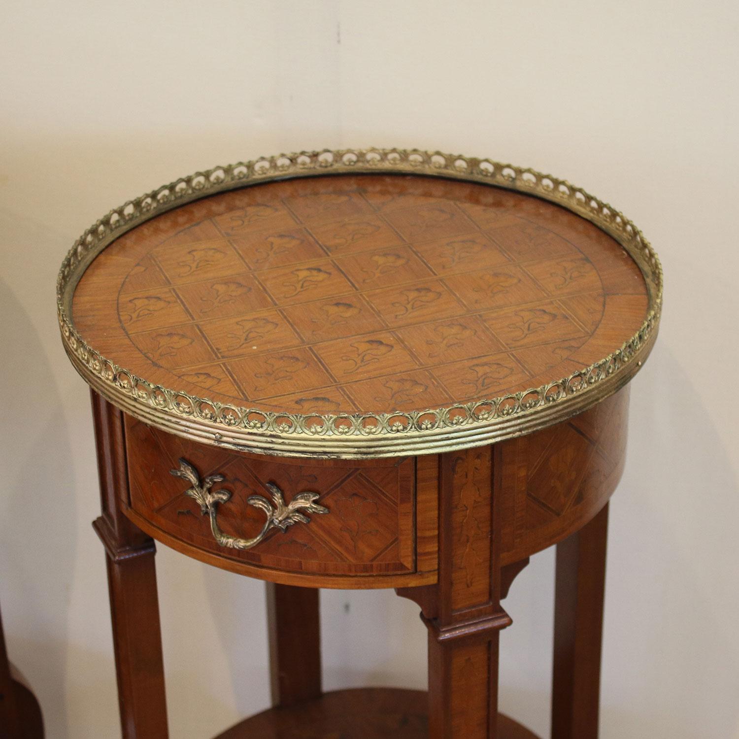 Matching pair of round bedside tables with fine inlay work and brass ormolu decoration.
 