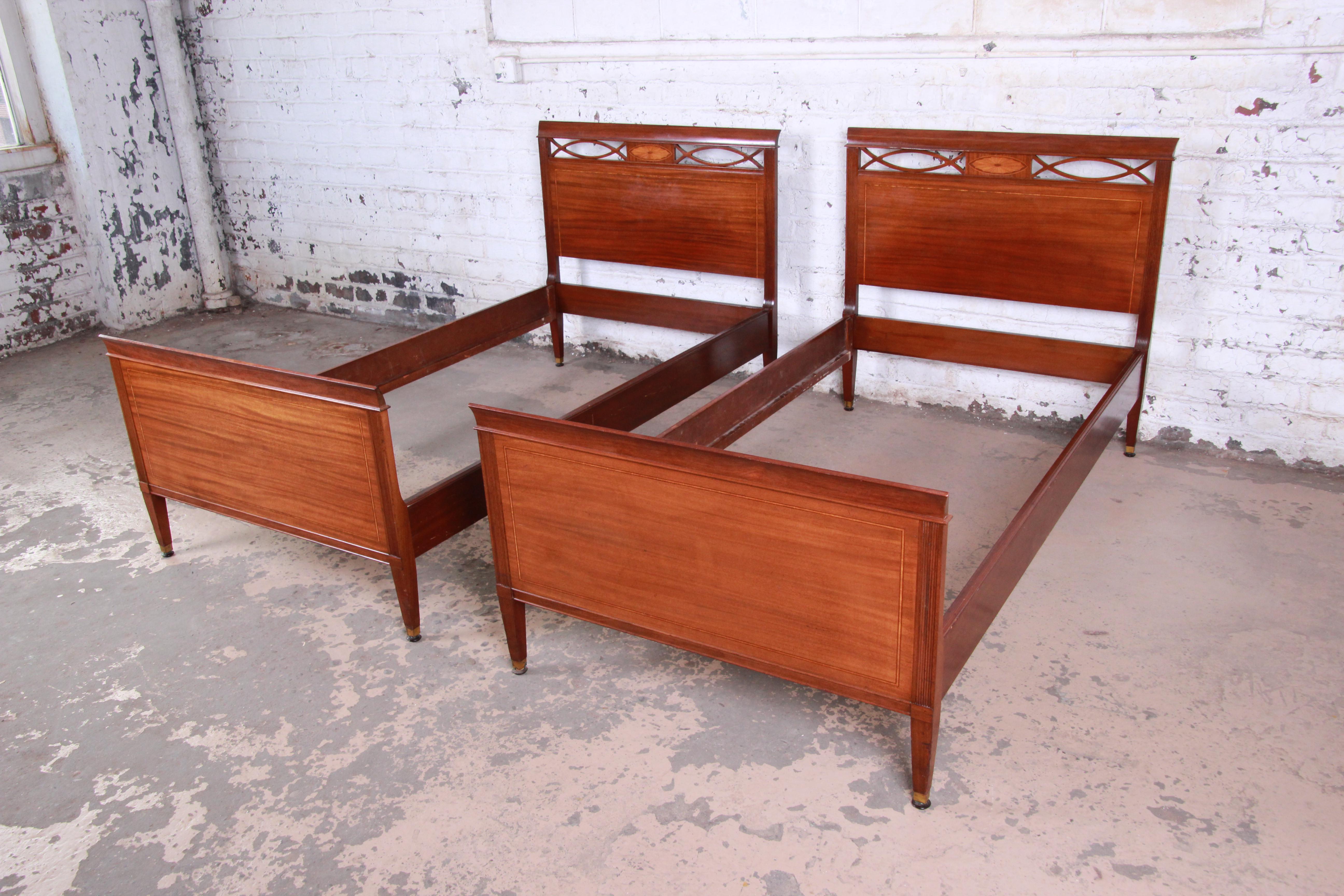 A gorgeous pair of vintage Federal style inlaid mahogany twin bed frames by Kindel Furniture of Grand Rapids. The beds feature beautiful mahogany wood grain with nice inlaid and carved wood details. Each retains the original Grand Rapids label. The