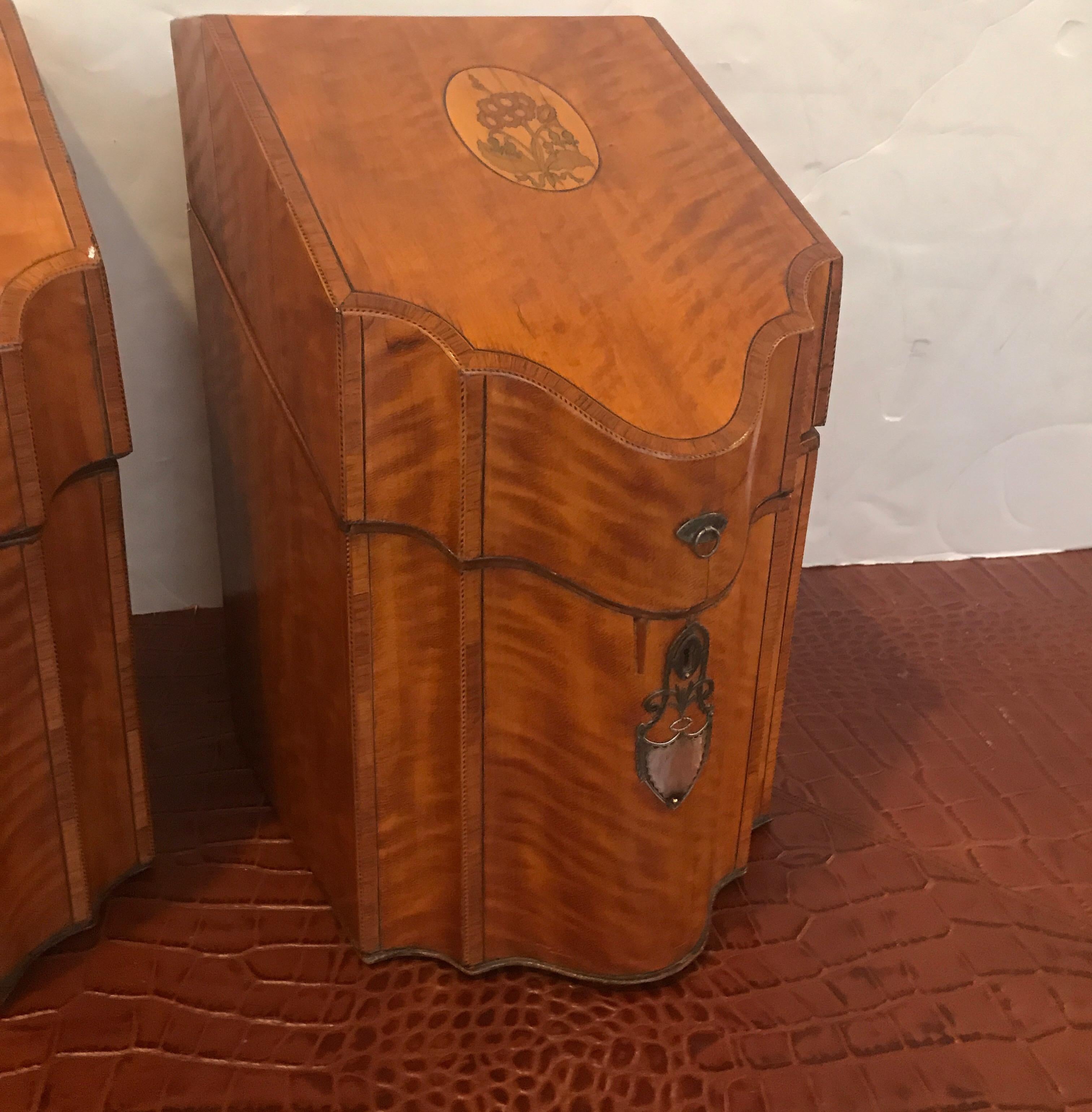 A pair of superb figured satinwood cutlery boxes with serpentine fronts. The tops lift to reveal the original fitted compartments for knives and flatware, the escutcheons are sterling silver.