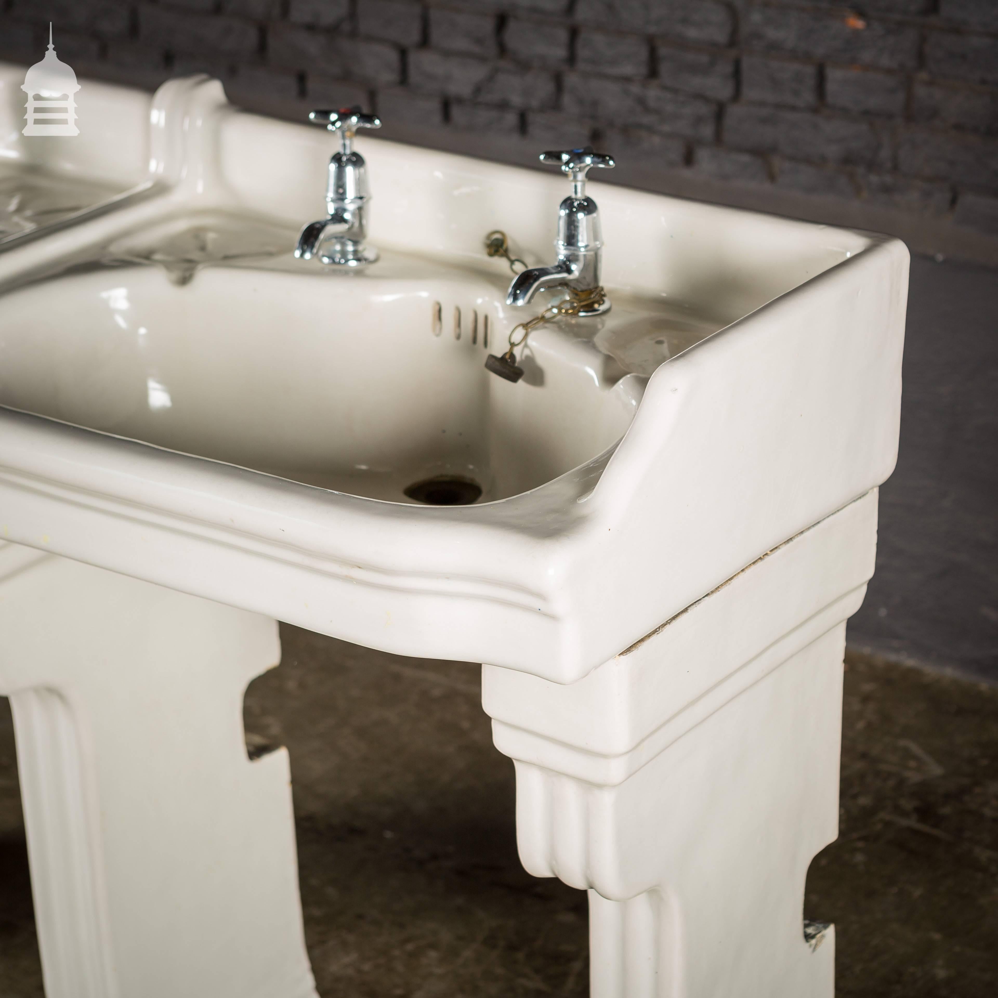 Pair of interlocking wash hand basins double basin on fluted ceramic stands.