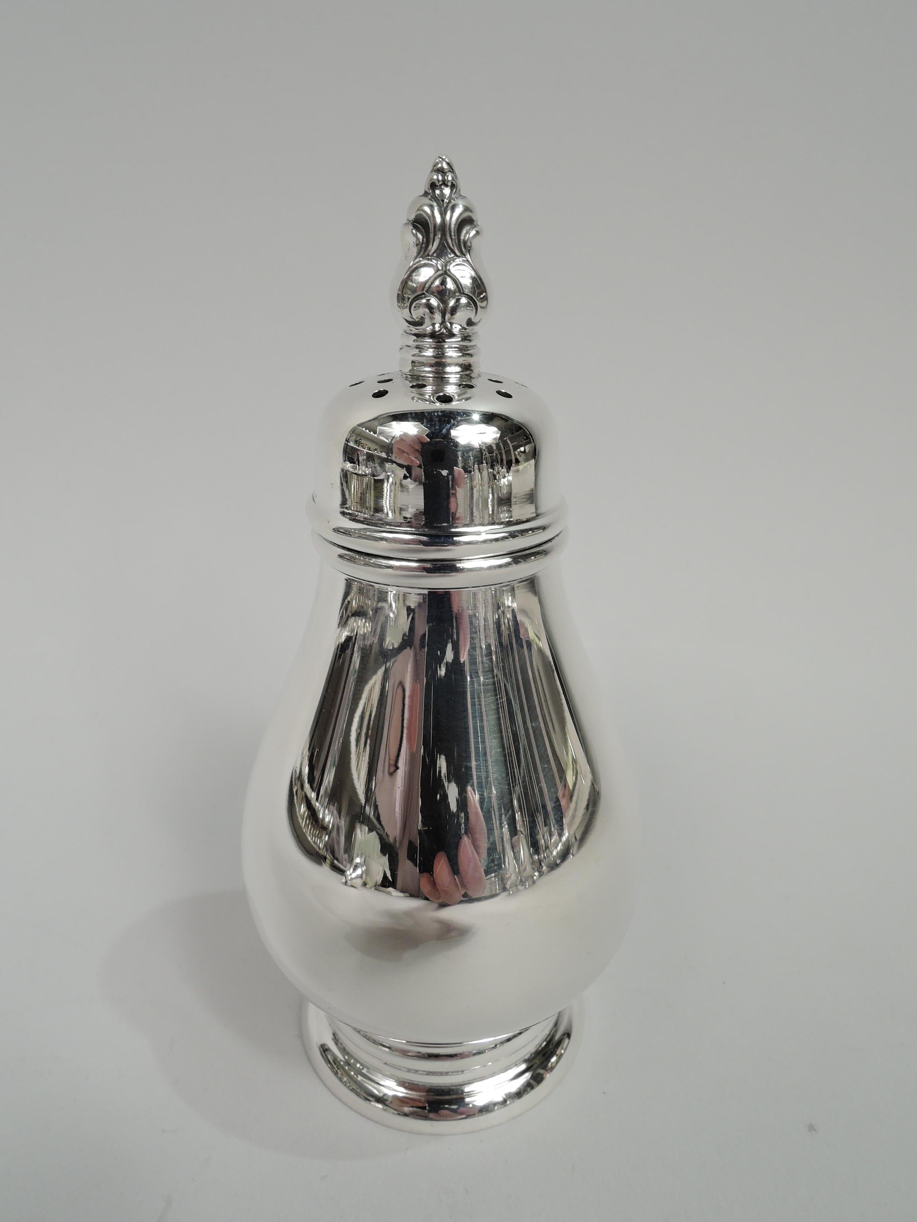 Pair of Royal Danish sterling silver salt and pepper shakers. Made by International in Meriden, Conn. Each: Baluster on raised foot with concentric bands. Cover pierced top and scroll and acorn finial. Fully marked including maker’s stamp, pattern