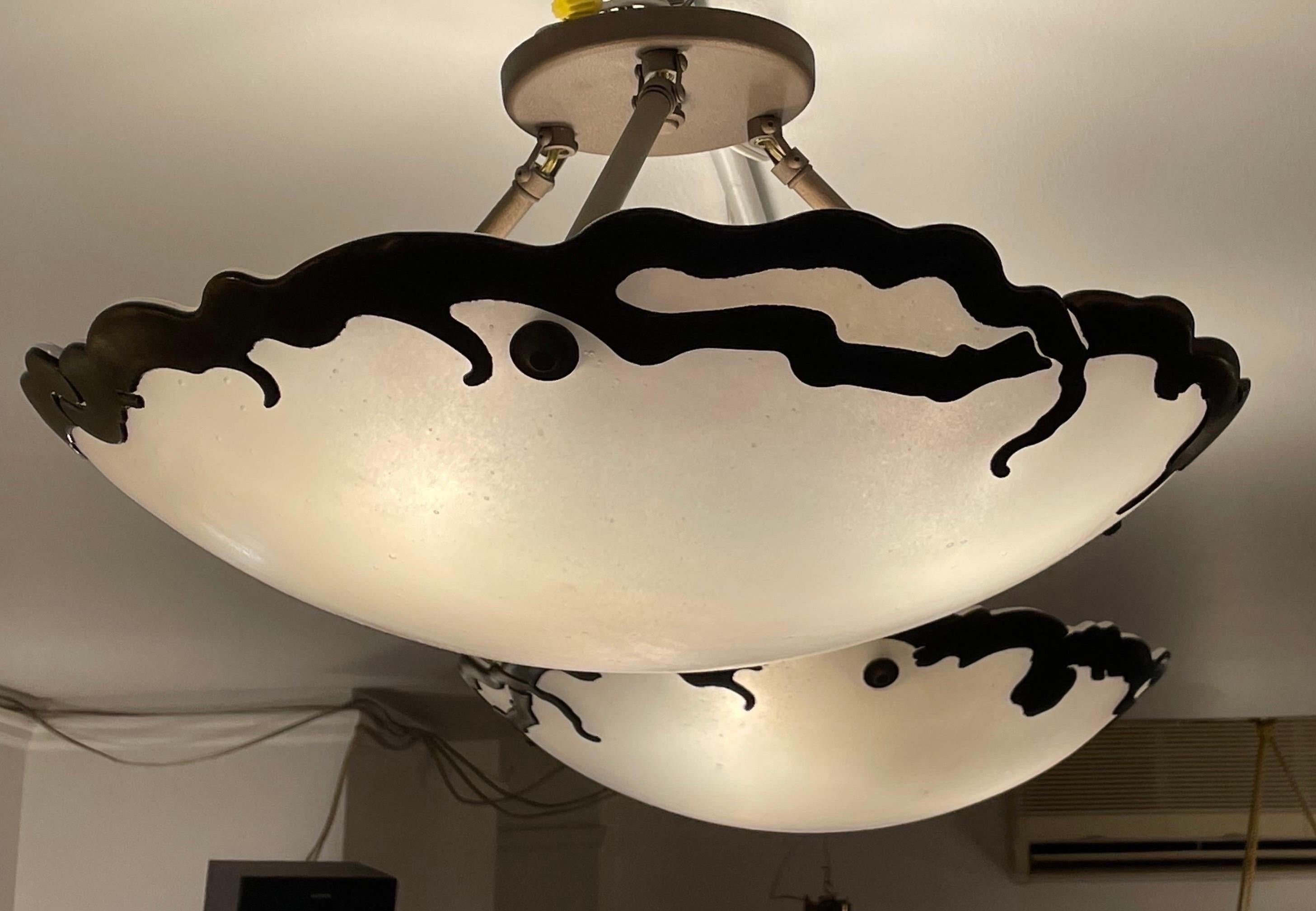 Une belle paire de luminaires lumineux avec des anneaux décoratifs en bakélite de couleur bronze. Recâblées à des chutes totales très courtes également sur des tiges bronzées, les lampes peuvent être recâblées avec des cordes si on le souhaite, et à