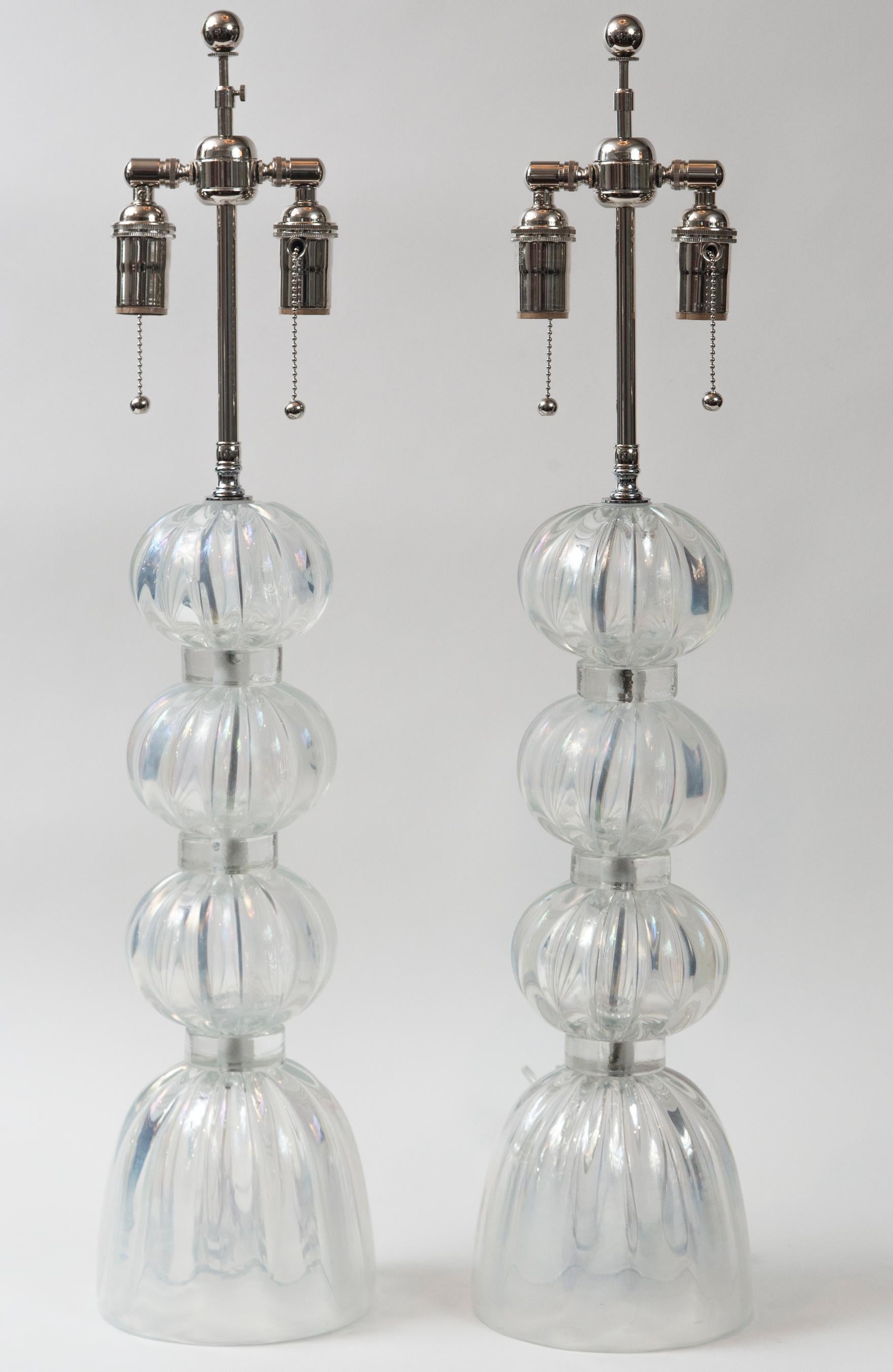 Beautiful pair of artisan blown iridescent clear ball lamps
 Electrified to code with UL approved parts, hardware in  polished brass with pull chains for 2 medium base bulbs per lamp and an on/off cord switch, lamping height adjustable.
Dating: new,