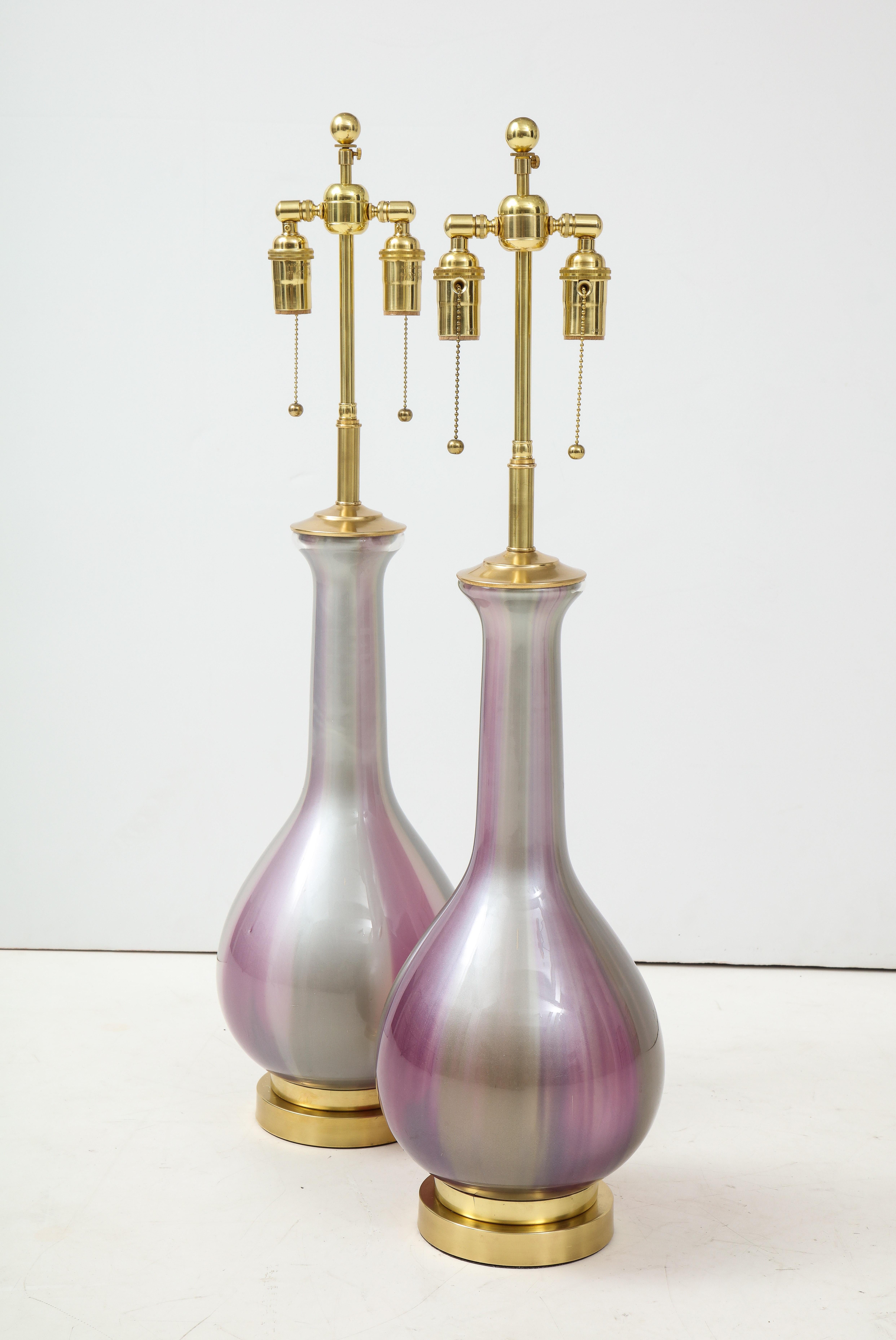 Pair of Iridescent lamps by Frederick Cooper.
The lamps have a foil applied in tones of Grey, Mauve and Lavender to the inside of the glass and
are mounted on polished brass bases which are newly rewired with brass double clusters.
On the