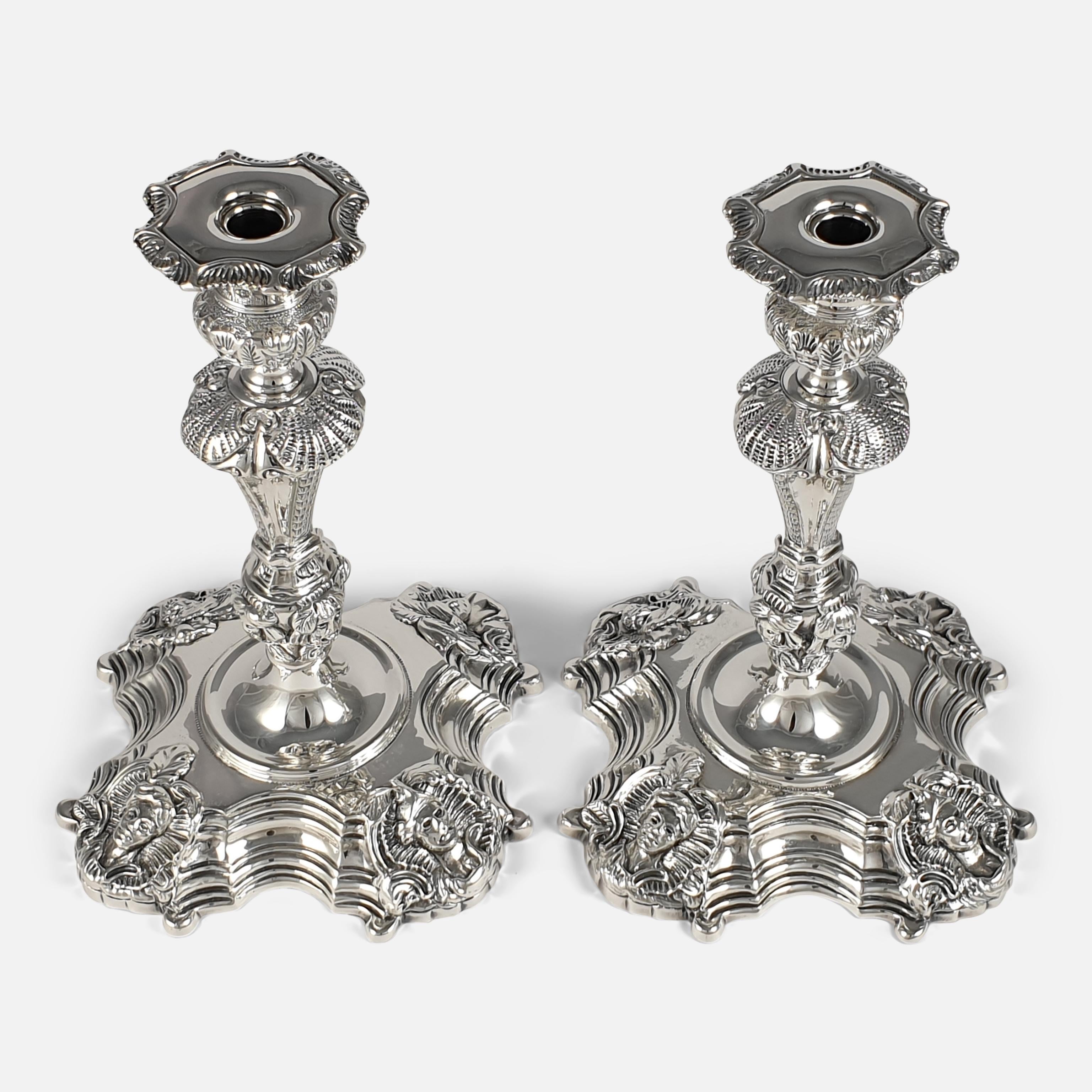 A pair of Irish cast sterling silver candlesticks by Royal Irish Silver Ltd, Dublin 1969, with import marks for The Sheffield Assay Office. The ornate candlesticks are of baluster shaped form, having detailed foliate work to the nozzles and upper