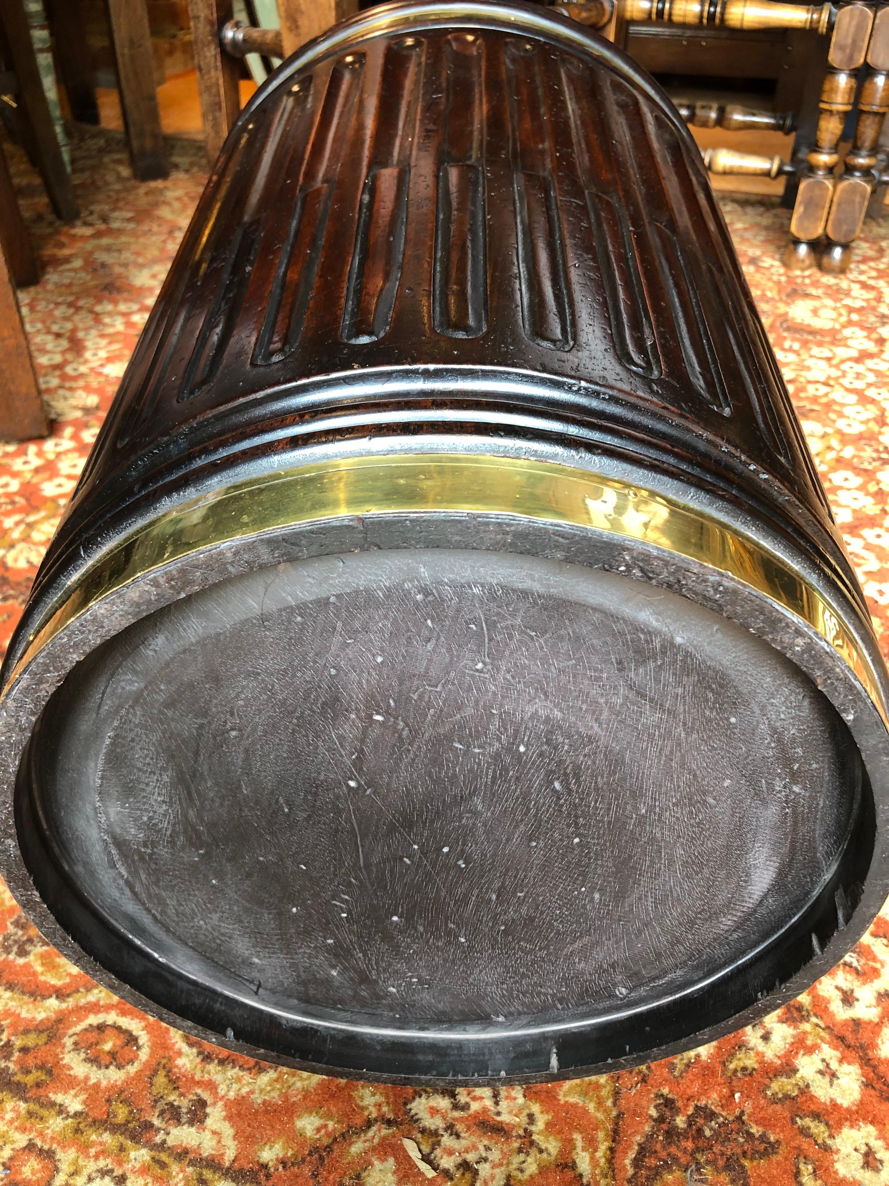 Very handsome pair of Georgian style brass bound mahogany turf, or Irish peat buckets. The tapered fluted moulded sides have polished brass bands with twist grip loop handles. The interiors are fitted with sealed brass liners, and can therefore be