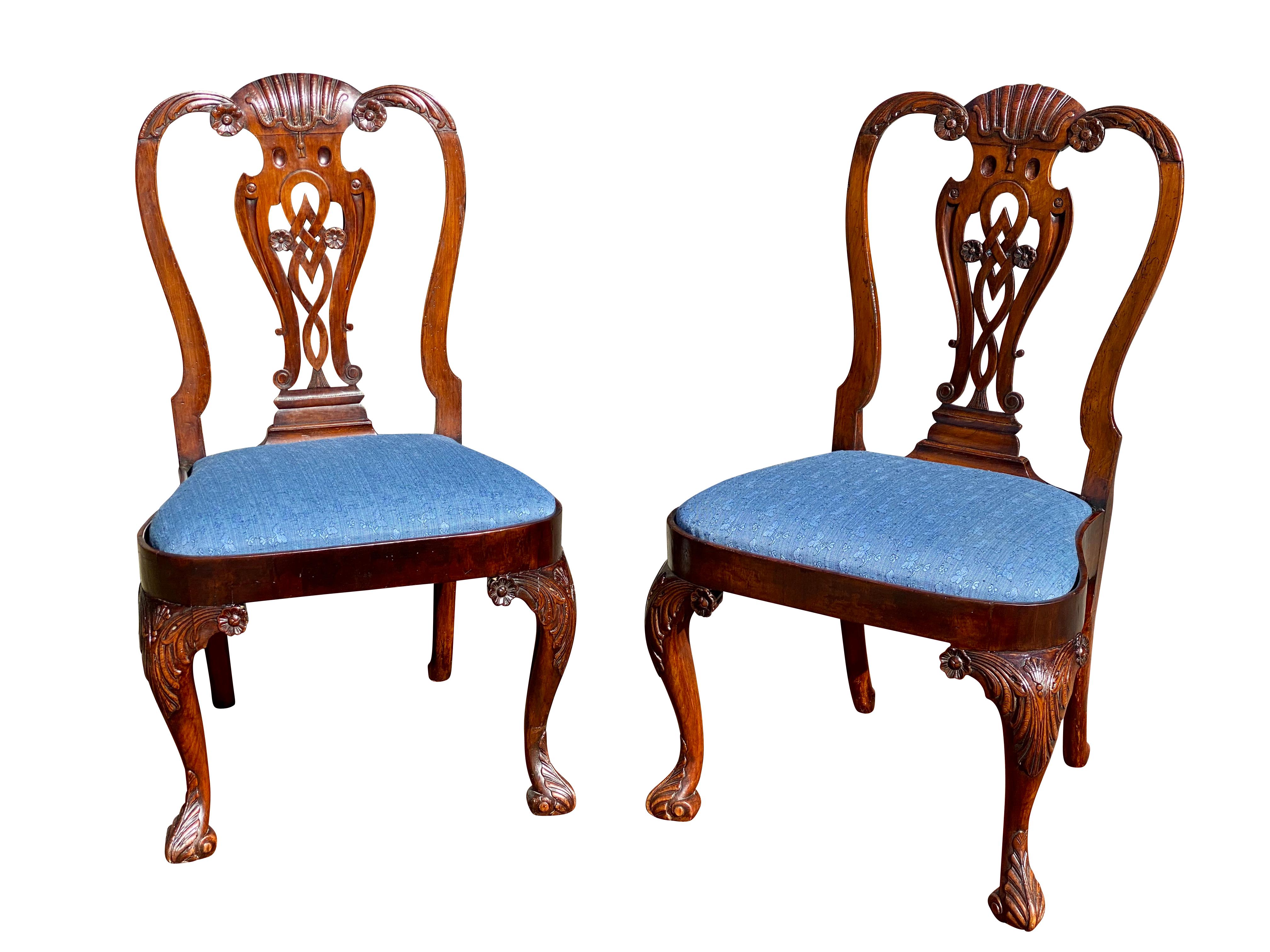 Each with a serpentine crestrail with shell and tassel carving, pierced carved vasiform splat, drop in seat and raised on carved cabriole legs with acanthus carving and flower head carved returns.