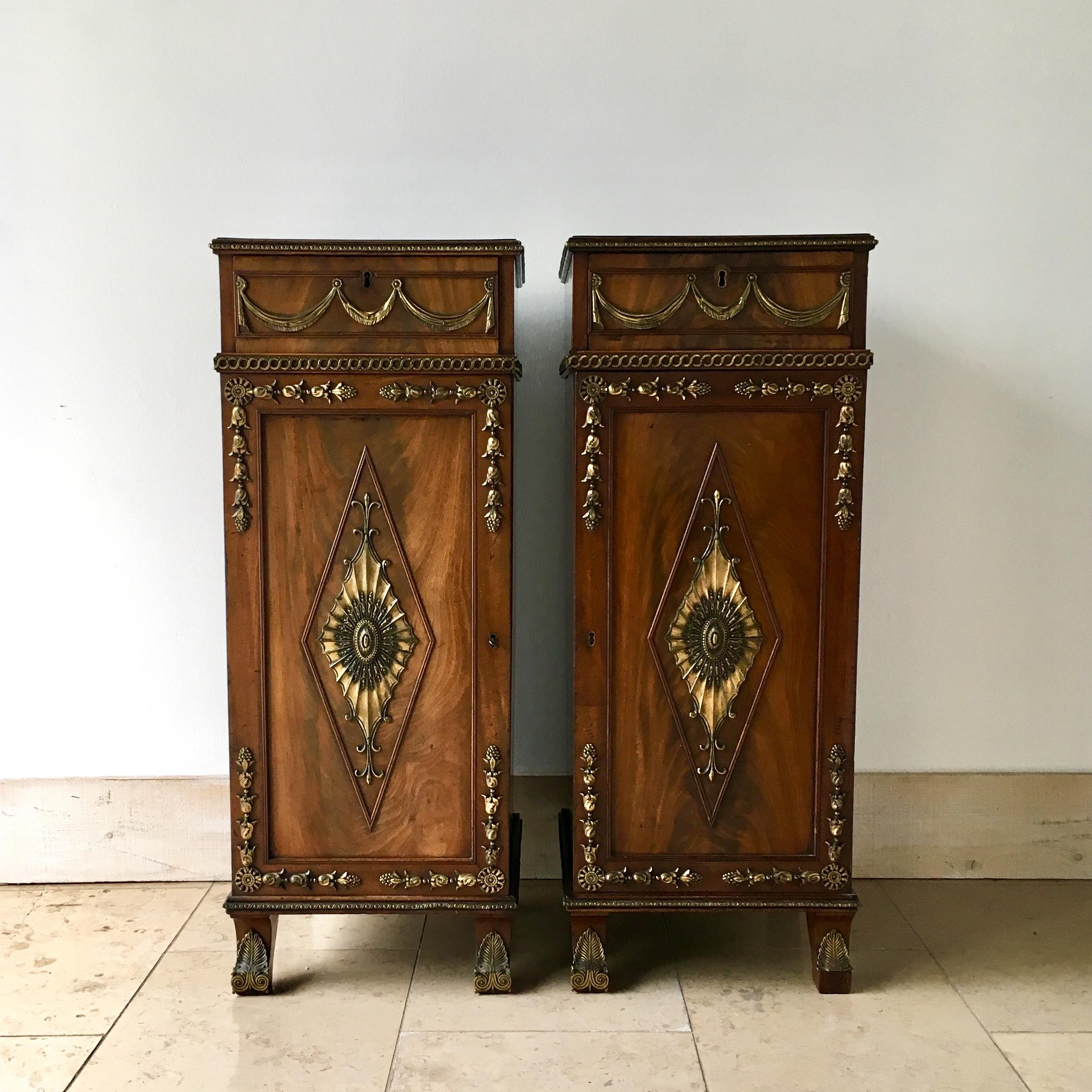 Pair of Irish Regency mahogany pedestals circa 1820 in unrestored original condition.

The pedestals each have drawers with ormolu swag detail and the doors have superb radiating ormolu fan detail. Each pedestals interior are fitted out with