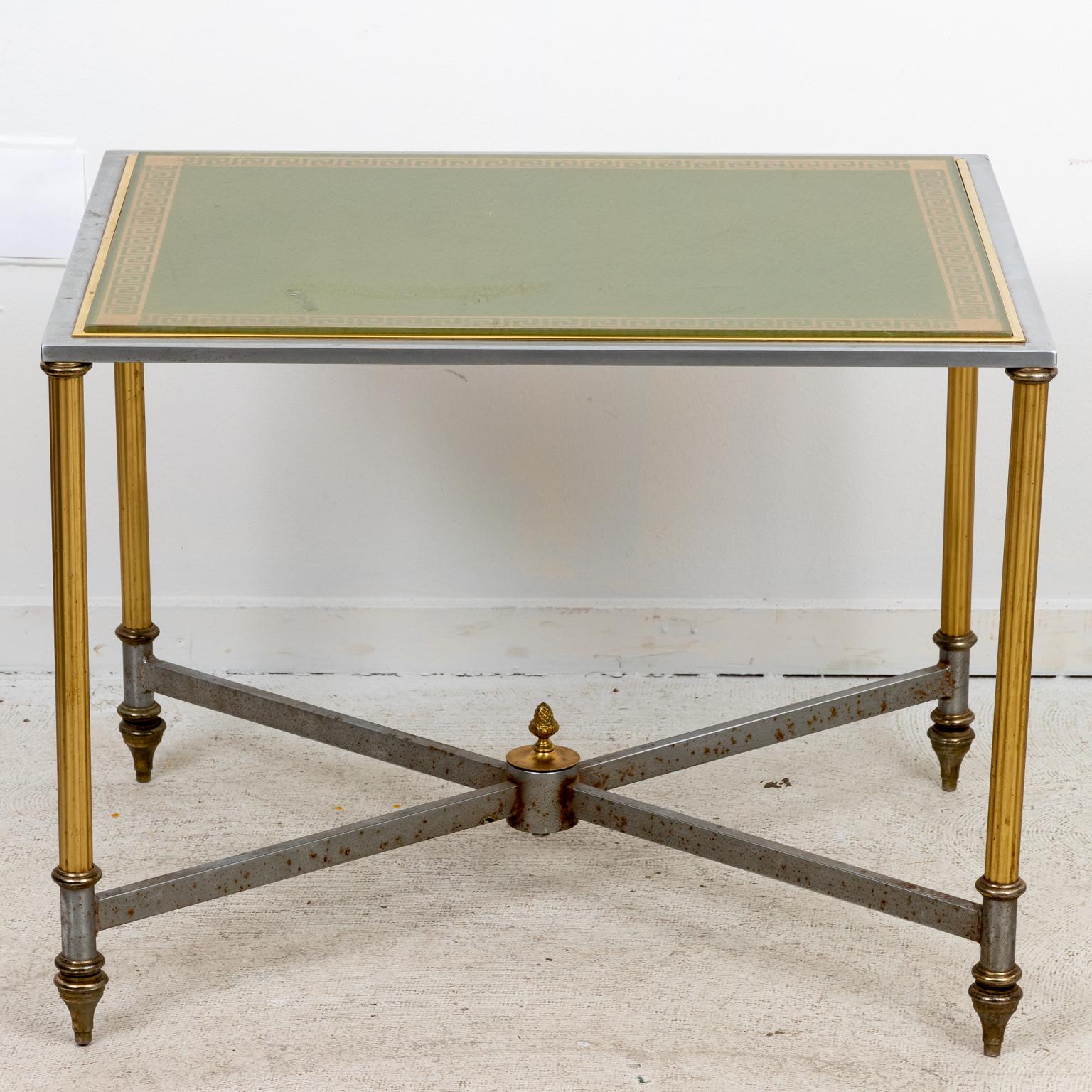 Pair of iron and brass side tables with Greek key decoration under glass top. The tables also feature x-shaped cross stretchers with center finial. Please note of wear consistent with age including patina, oxidation, and scratches to the metal.