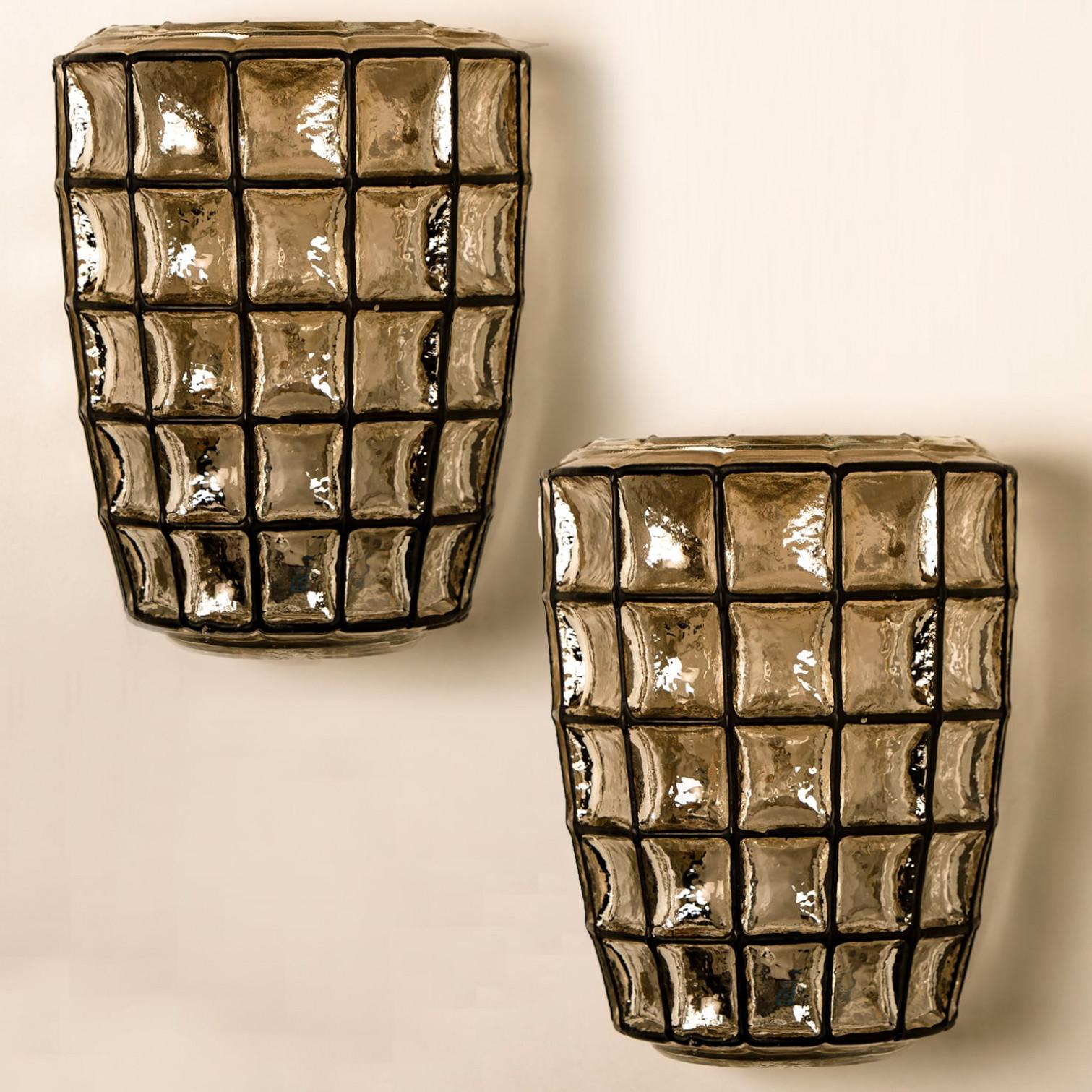 This beautiful and unique pair of hand blown glass wall lights were manufactured by Glashütte Limburg in Germany during the 1960s (late 1960s or early 1970s). Beautiful craftsmanship. These midcentury lights feature handmade, elaborate clear bubble