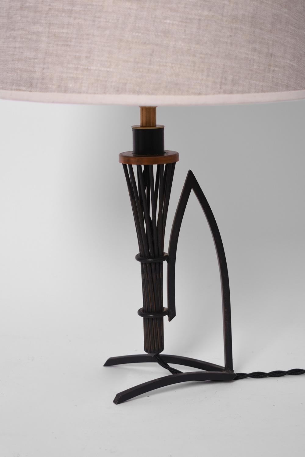 Coppia di lampade da tavolo in ferro battuto e rame che poggiano su una base che regge un cono fatto di bastoncini di ferro. Francia, anni '40. 
